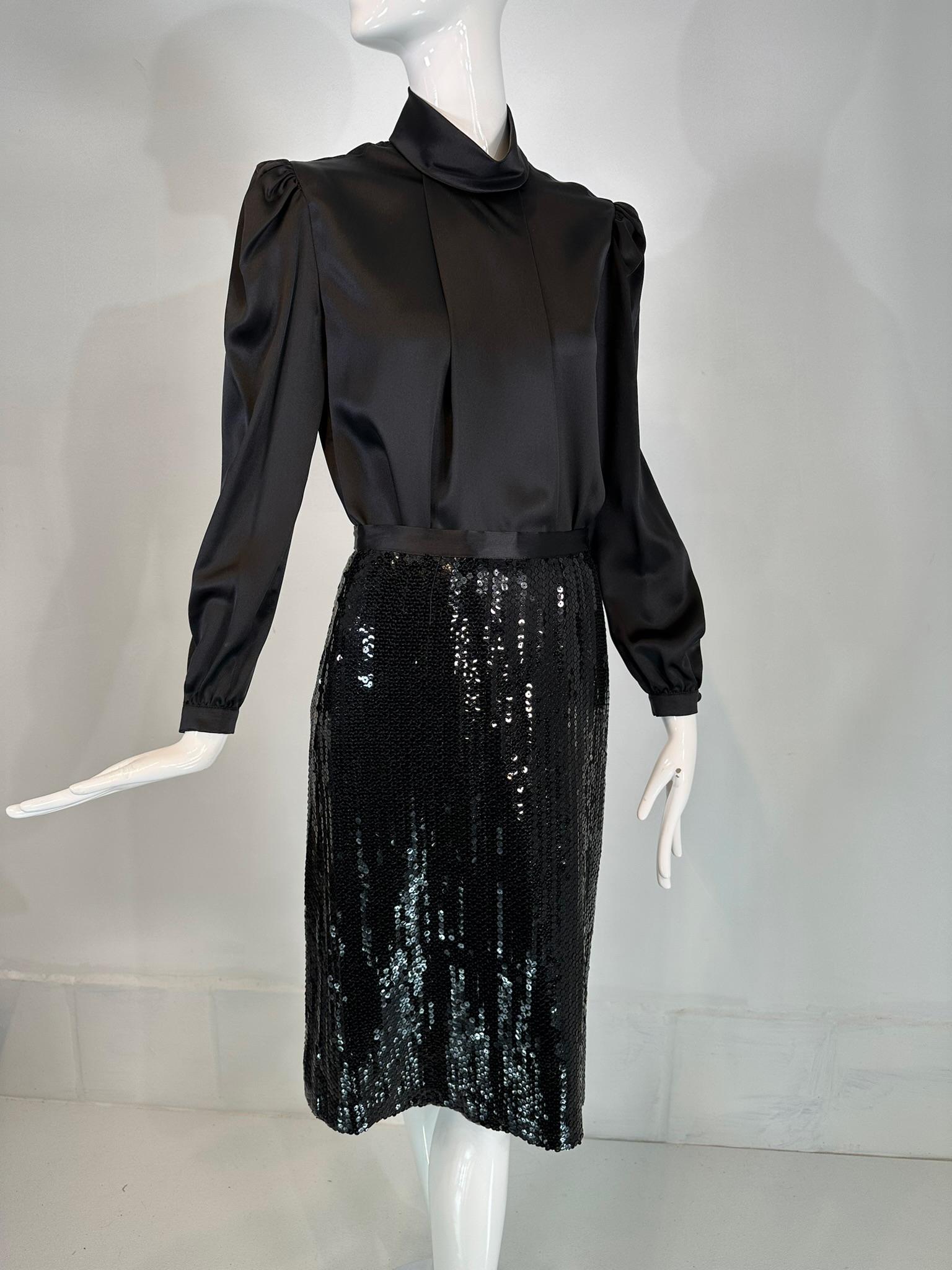 Adolfo 1980s black satin poet sleeve blouse  coordinating black sequin pencil skirt. Pull on black satin blouse has a turtle neck, at the front there is a wide open pleat from the neck to the hem, net pads on the inside shoulders for definition.