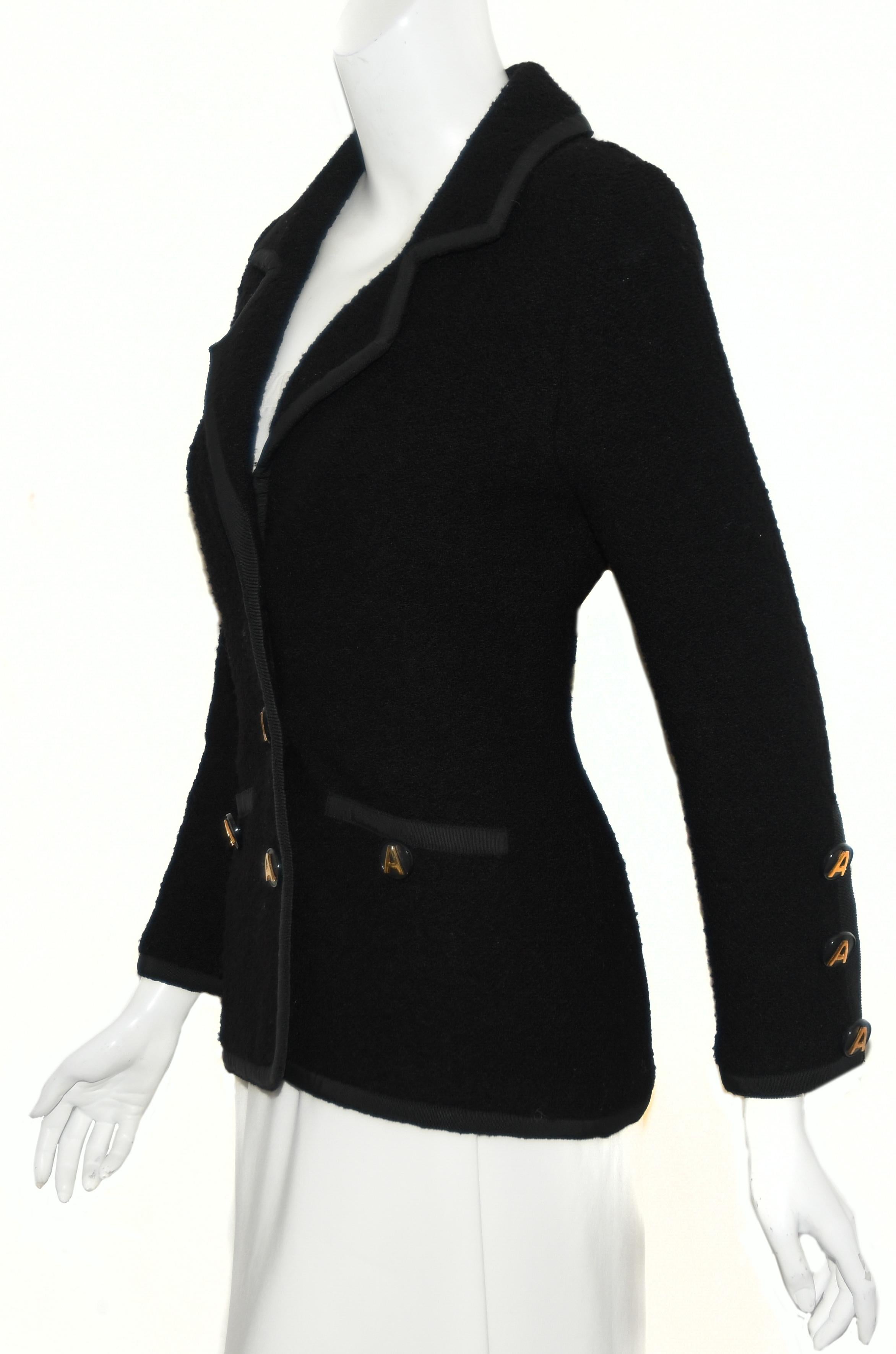 Adolfo black tweed knit  jacket is trimmed with black grosgrain ribbon around the notch collar and front opening.  This jacket has two faux pockets trimmed in the grosgrain  as well as the hem and cuffs.   For closure,  3 large Adolfo 