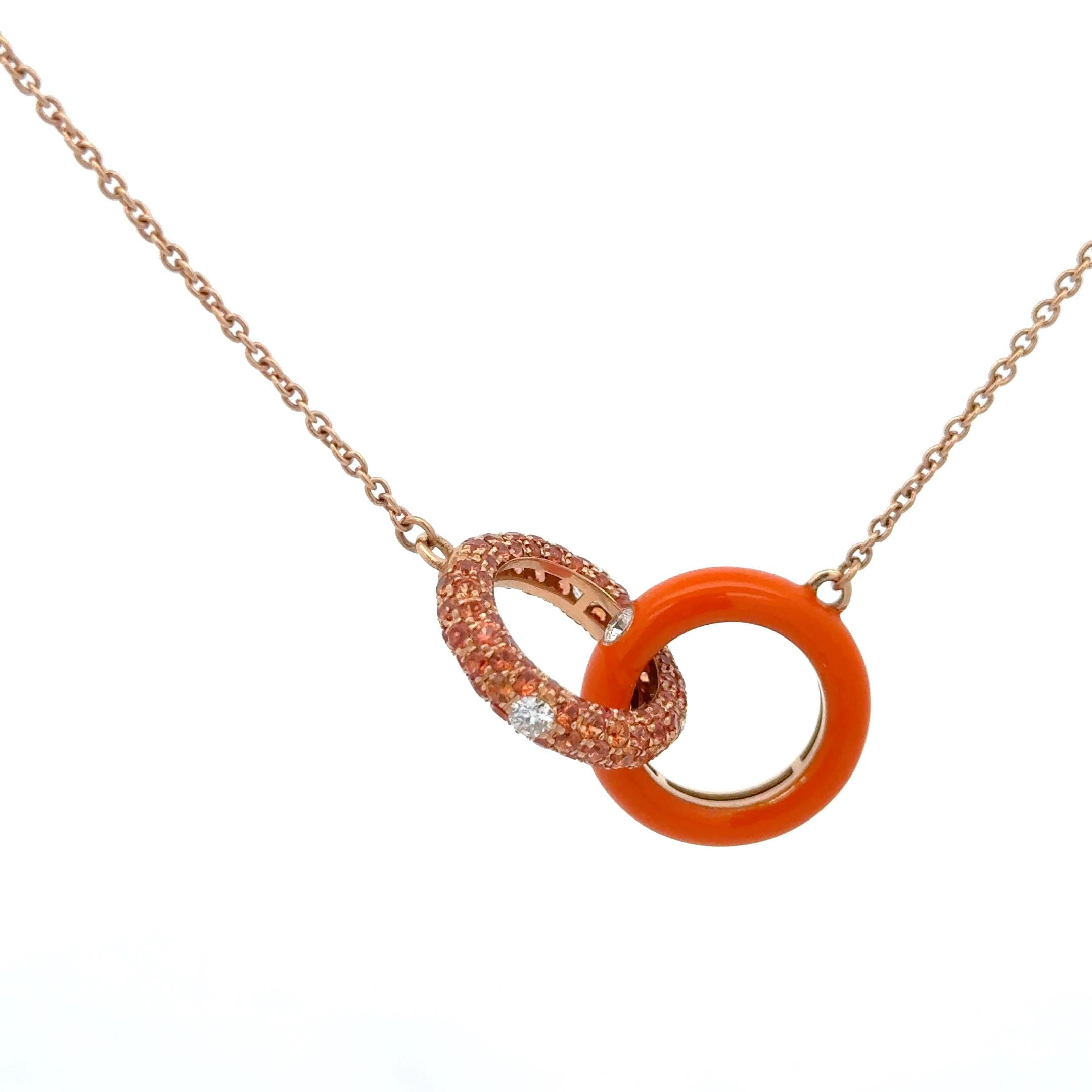 Adolfo Courrier Enamel Orange Sapphire & Diamond Pendant Necklace in 18K Rose Gold. The necklace features two interlocked rings, each with its own design, One is an orange enamel ring with a brilliant round diamond, and the other ring features pave