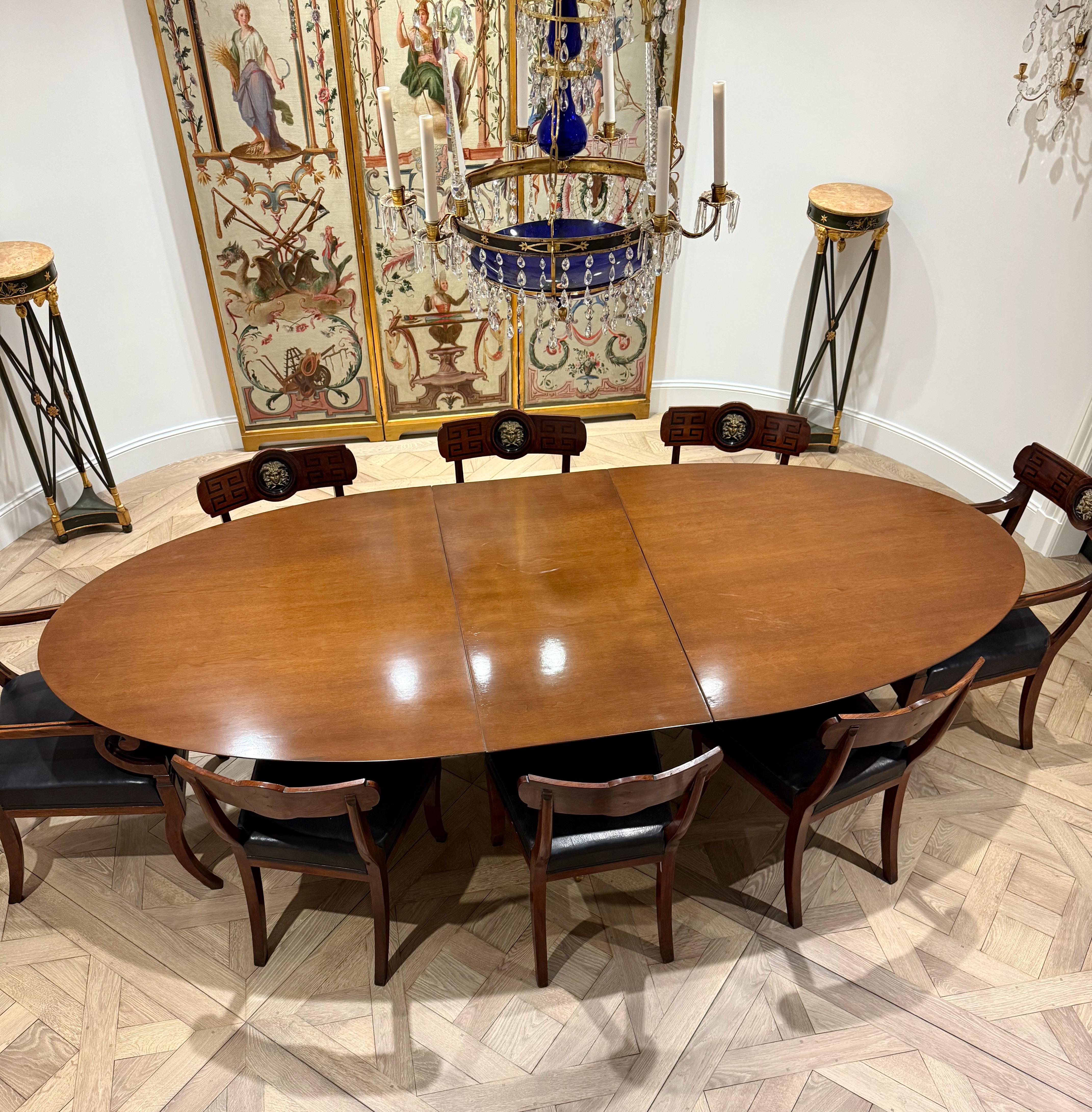 Tavolo da pranzo modernista in noce della fine degli anni Cinquanta, con piano ovale ellittico lucido su un piedistallo singolo satinato, quattro gambe allungate e affusolate intorno a un cerchio in ottone, sabot in ottone e piedini a sfera che sono