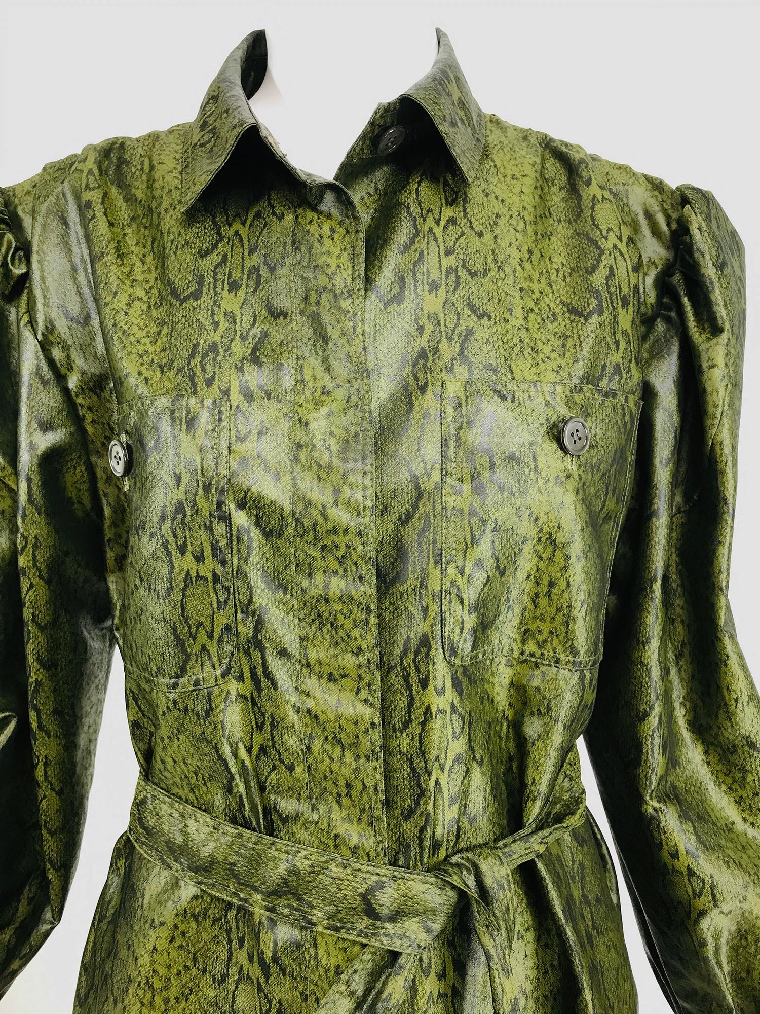 Adolfo green silk textured nylon snakeskin print print rain coat from the 1980s. Hidden button front placket closure coat, with narrow collar, shirred shoulder seams, peaked shoulder and full sleeves with gathered button cuffs. Breast patch pockets