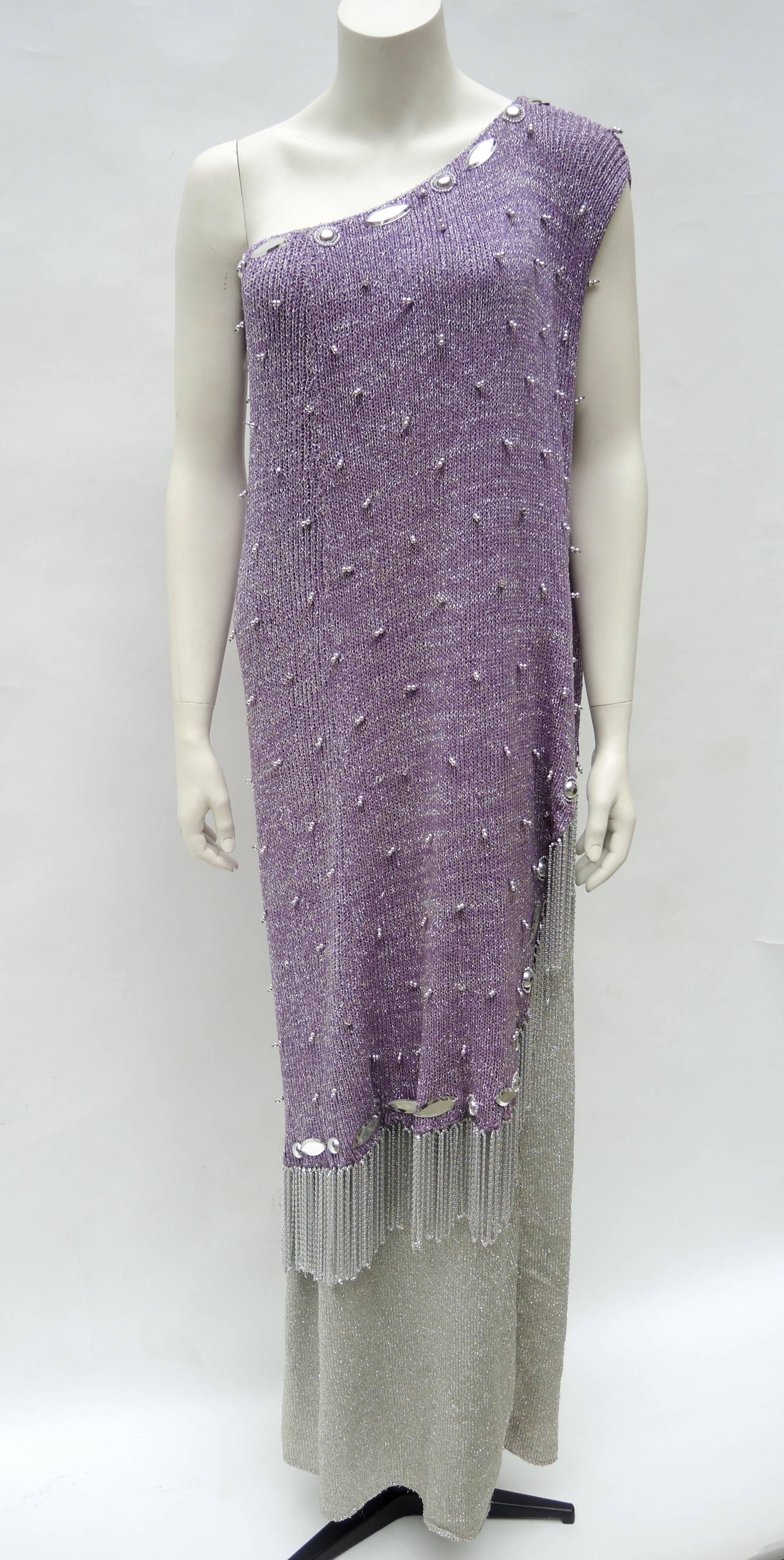 A rare and stunning dress made by the legendary socialite designer of the 1970's Adolfo. The 1970's red carpet worthy knitted purple and silver one shoulder gown is made in two layers ;the top knitted purple and silver layer is sewn with silver