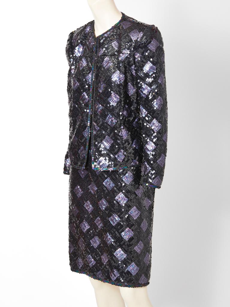 Adolfo, dinner suit, encrusted in black and purple iridescent sequins, that form a diamond pattern. Jacket is fitted with a jewel neckline that ends below the hip. Skirt is straight.