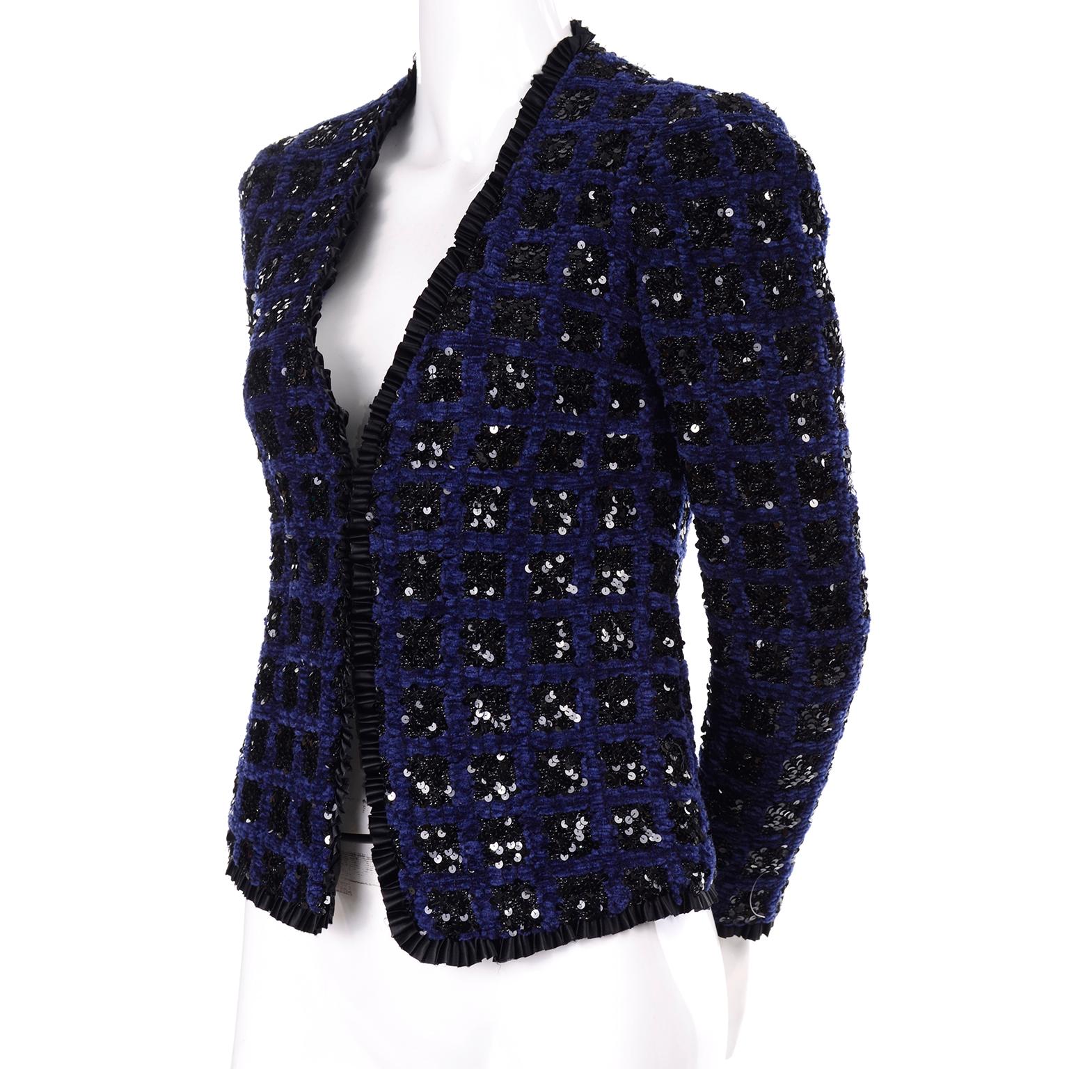 This is a gorgeous Adolfo open front blazer that has unique squares of black sequins on rich blue chenille. It is trimmed with a ruffled satin fabric that has a raw edge. It is fully lined and is in excellent condition. Fits like an extra small or