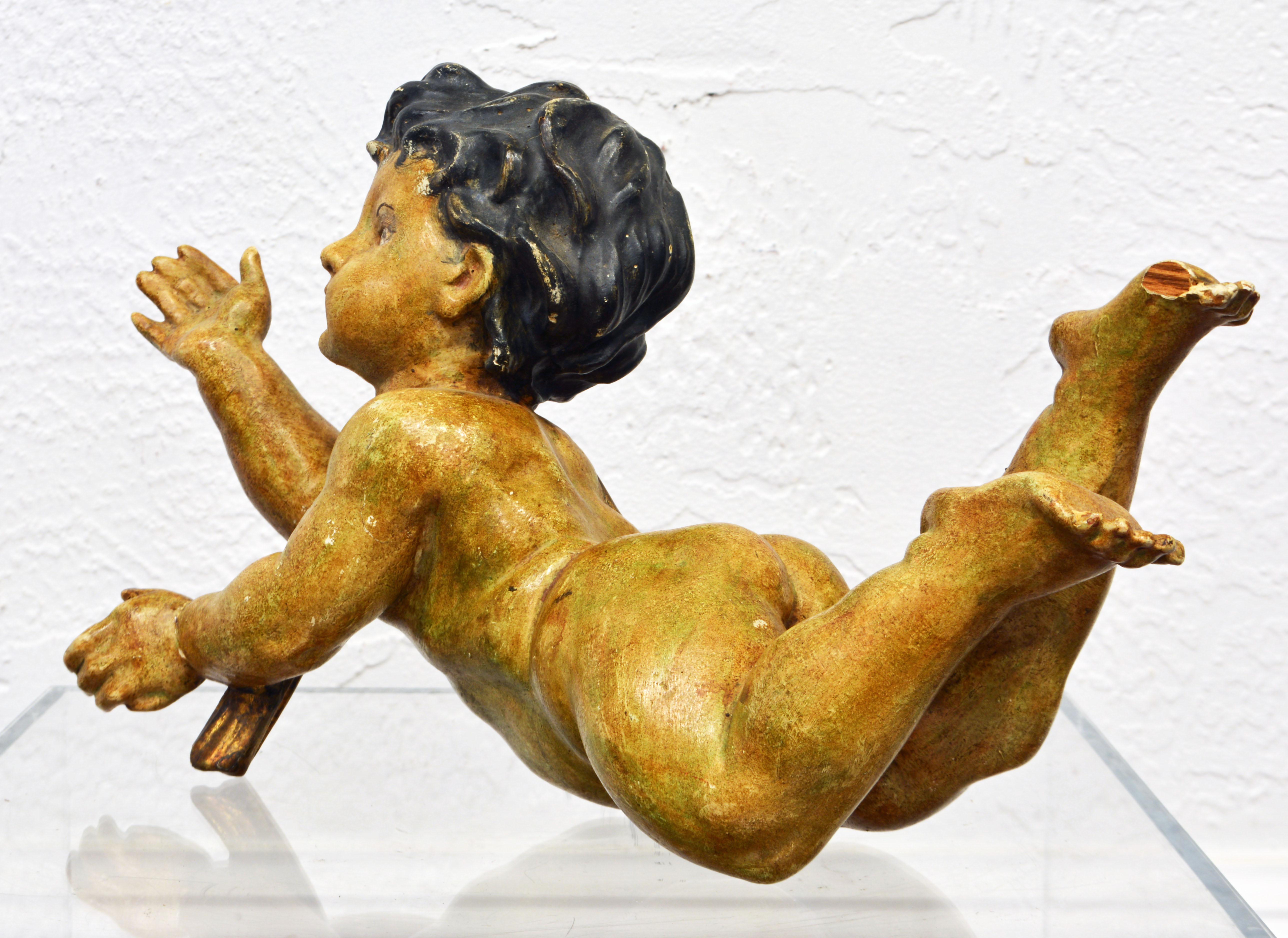 This fine Italian 19th century carved putti figure is well proportioned and detailed. The surface is partly gilt with a painted gold tinted body and dark painted hair.