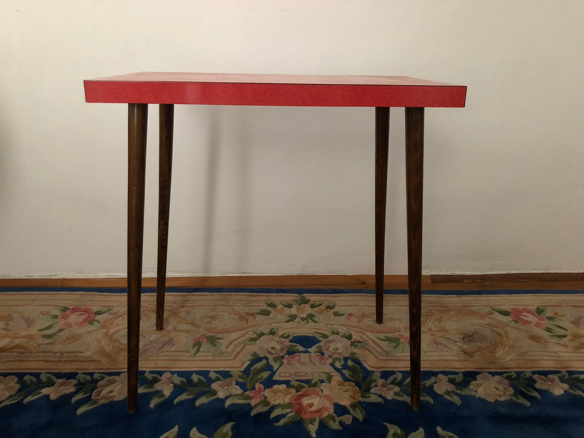 This rare Austrian unattributed design jewel is from the 1950s.
The Resopal top is pink and the legs are made out of cherry wood. The legs are standing rectangular and gives a very fun edge to it.