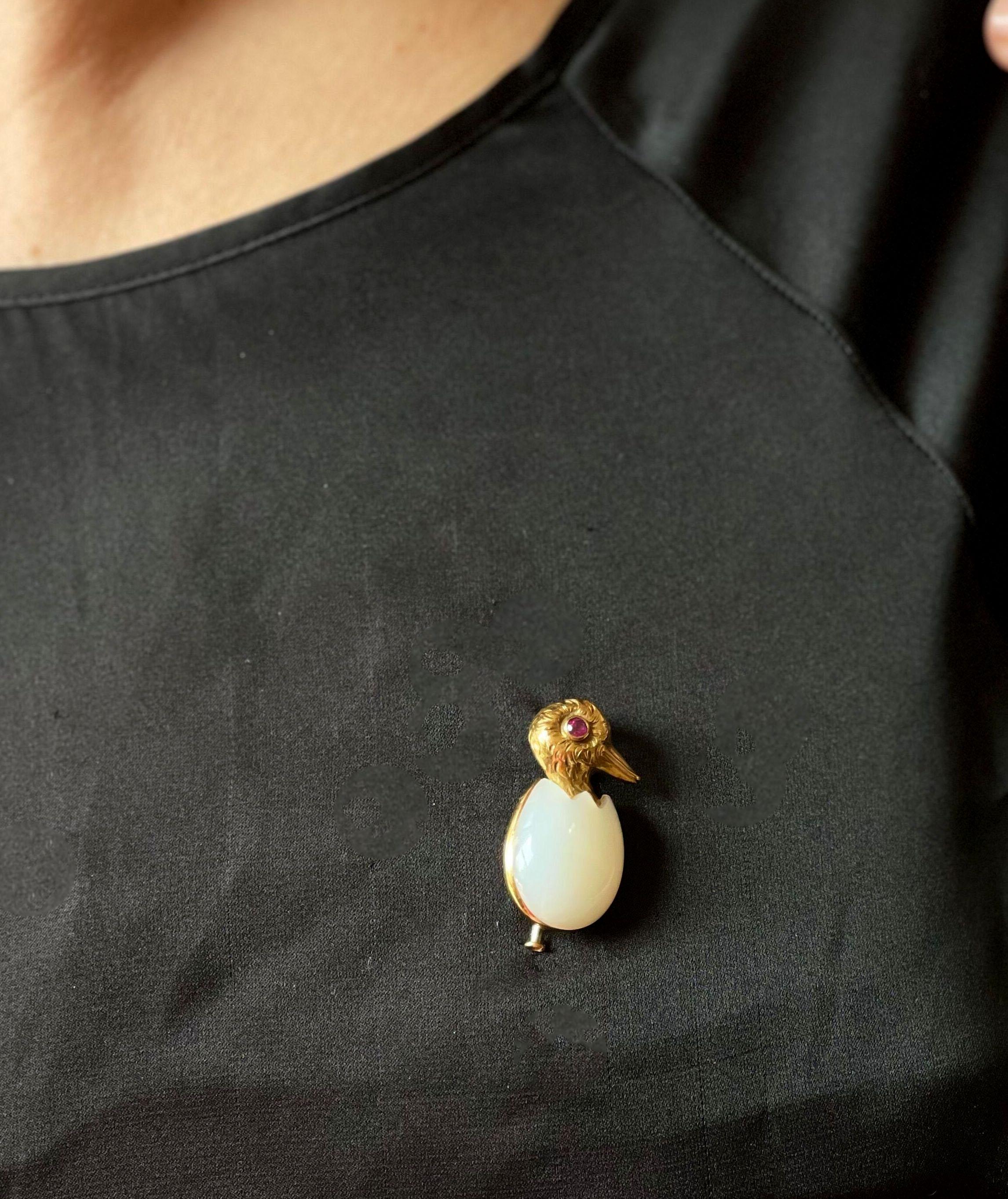Adorable and unique Cartier brooch, set in 18k gold, featuring a duckling in an egg shell, with chalcedony and ruby eye. Brooch measures 1.25