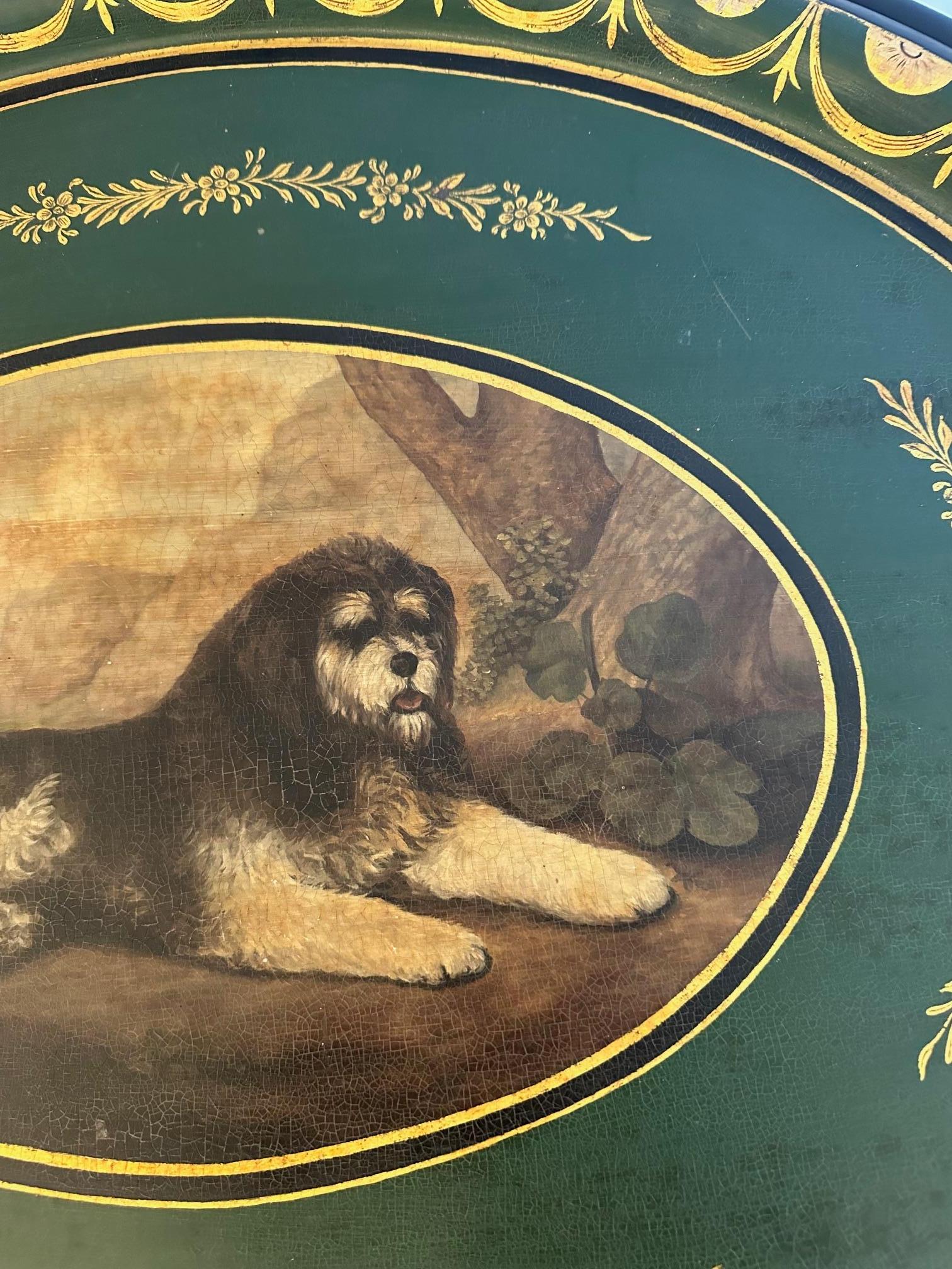 Chanteuse et polyvalente table à plateau ovale en tole avec chien peint sur le plateau amovible.  Base en bois noir et or coordonnée.

