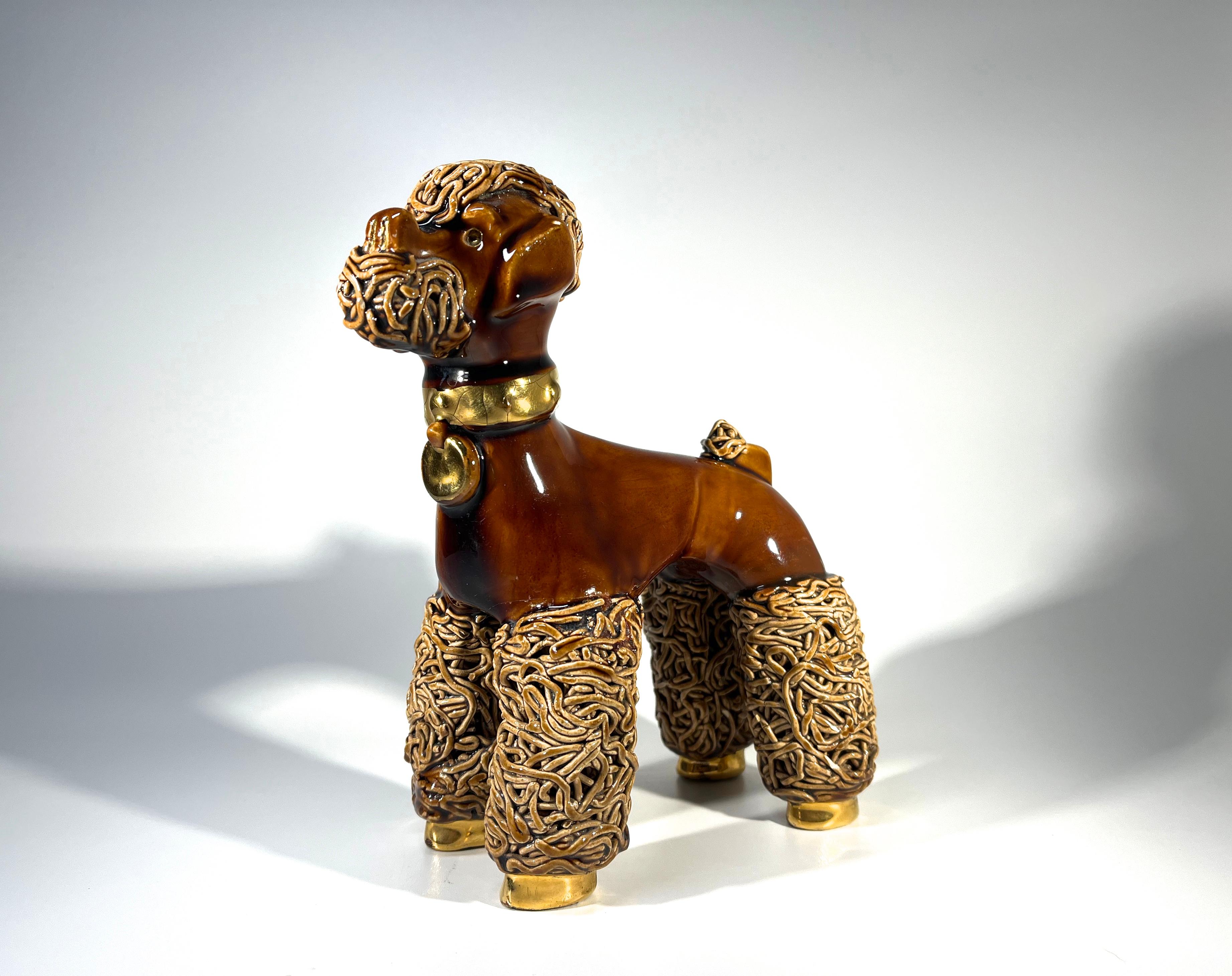 Sporting a 'Dutch Cut' to his coat, this adorable ceramic poodle stands tall and proud
Collar and feet are gilded, the glaze is a delicious toffee caramel colour and the eyes are pink glass.
Understood to have resided on a lady's nightstand
Circa