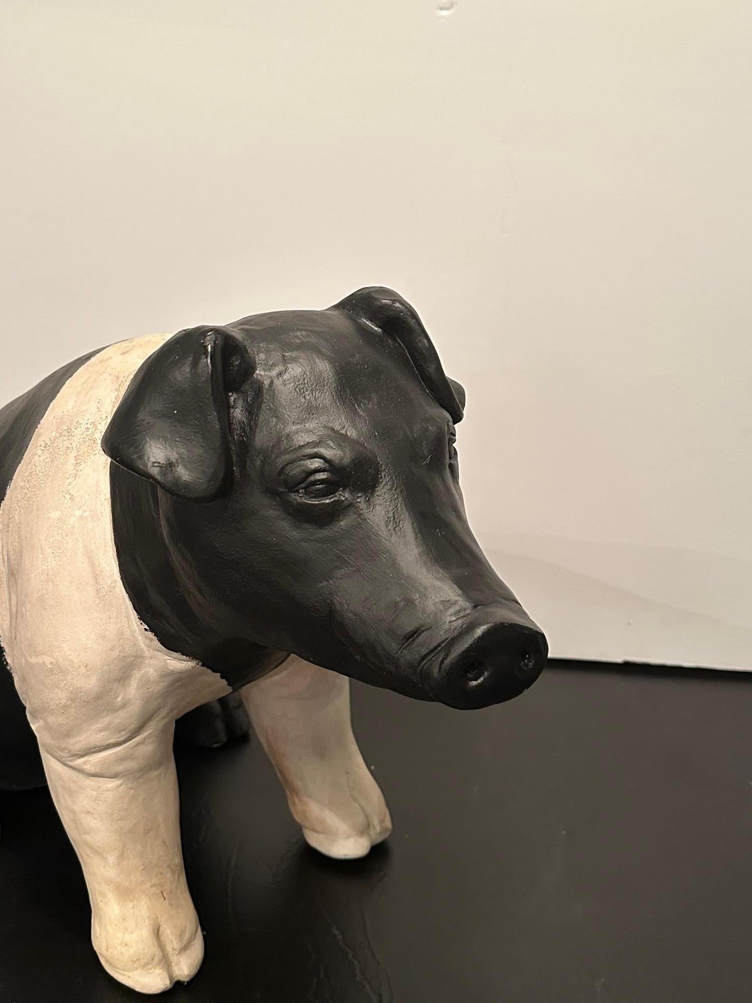 Eye catching whimsical plaster sculpture of a pig in black and white, originally used in a butcher shop’s window.