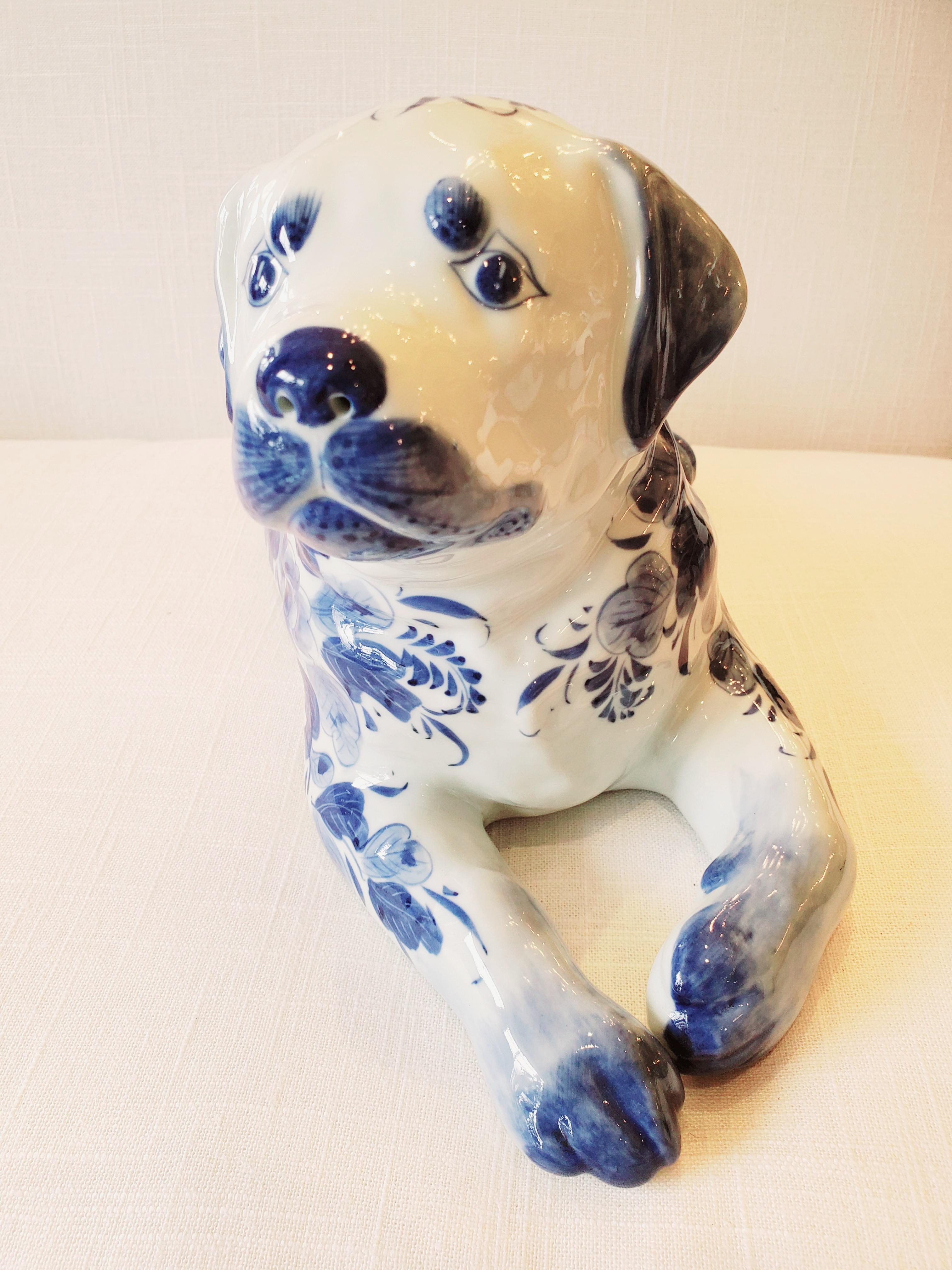 An adorable reclining porcelain dog accessory to dress up any book shelf or table in a pretty blue and white pattern.
