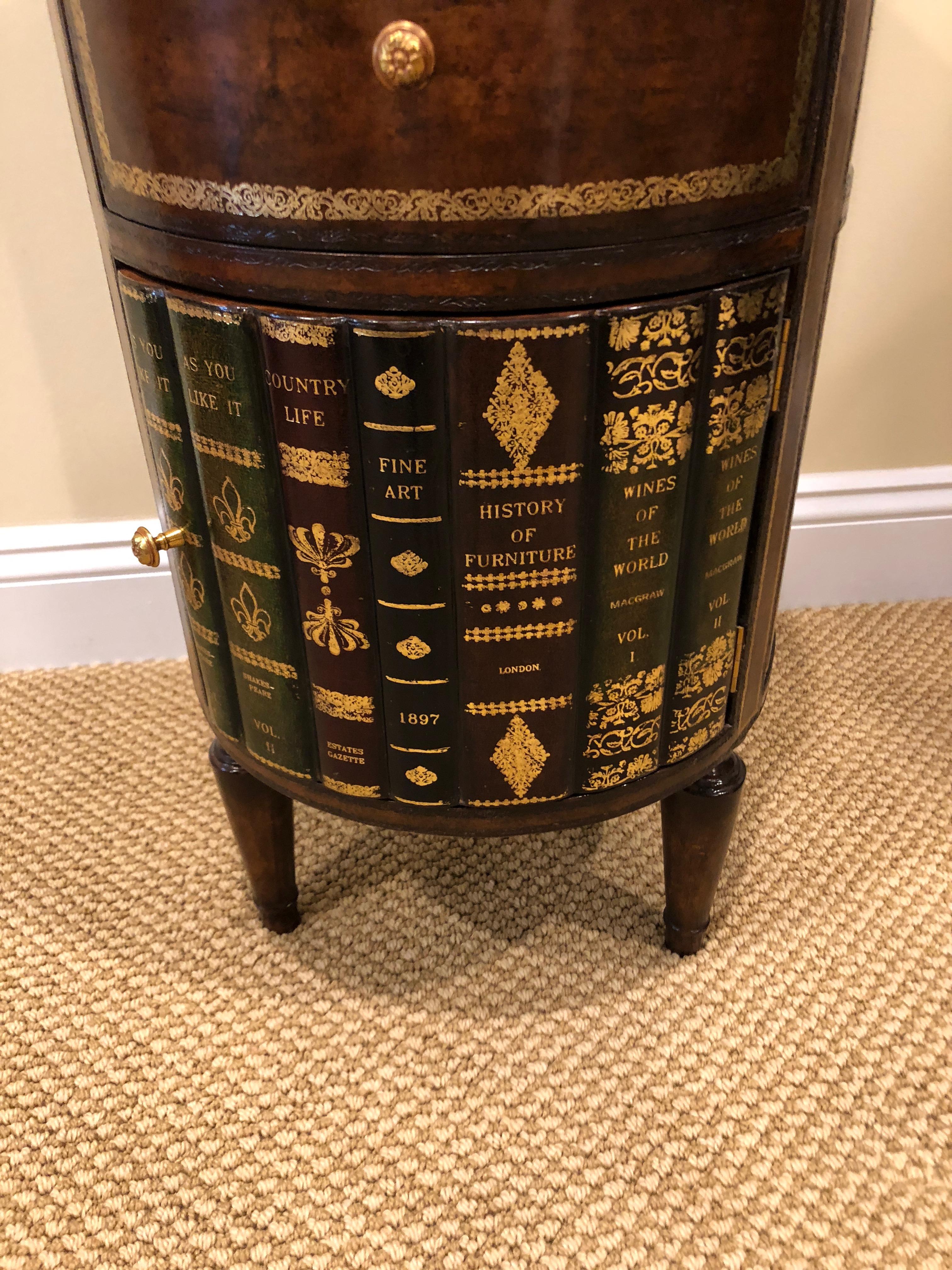 Fabulously fun round tromp l'oeil end table that looks like a collection of leather library books. Two drawers on the front are over a door that opens to reveal storage inside. Beautifully crafted including a tooled leather top.