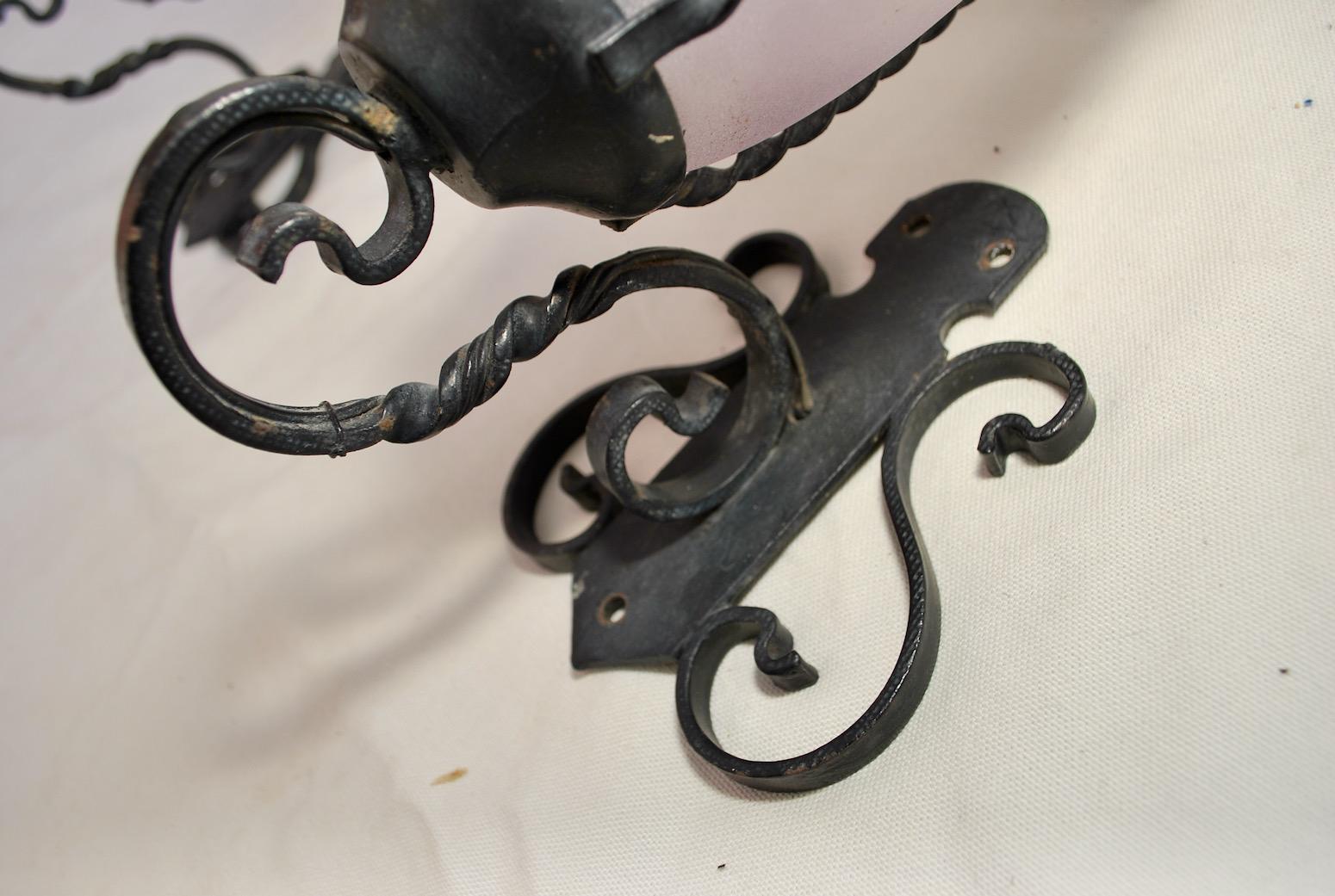 A really cute small pair of French wrought iron sconces, one of the glass turn to an amethyst color, I believe it was more exposed on the sun, then the other one, it is a true pair, except the sun change the color on one glass, all our lights and