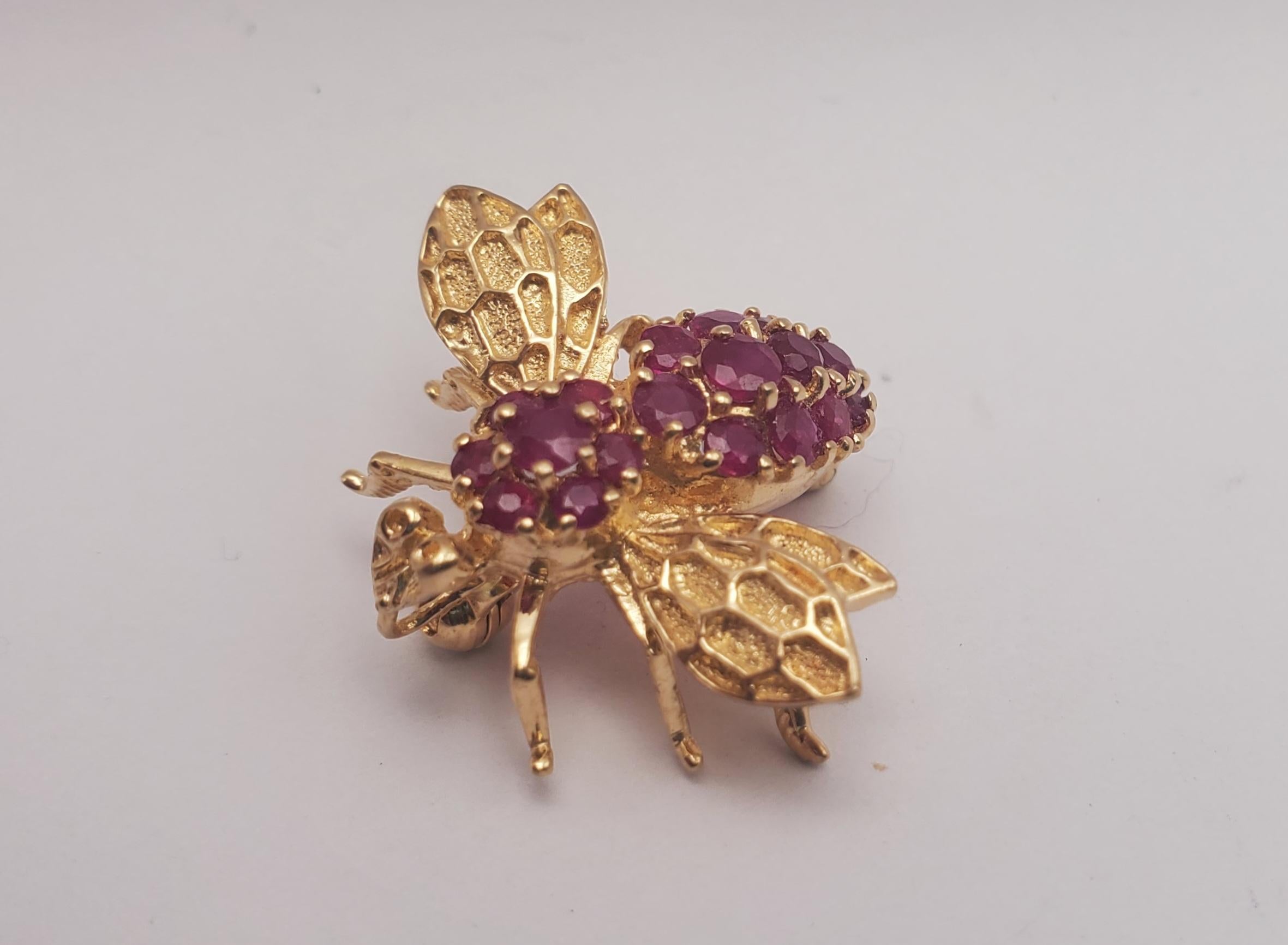 Incredibly detailed and darling bee pin/brooch crafted from solid 14k yellow gold. The piece features a bee insect design that is set with (20) fine quality rubies across its back. The round brilliant cut stones bring such an eye-catching quality to