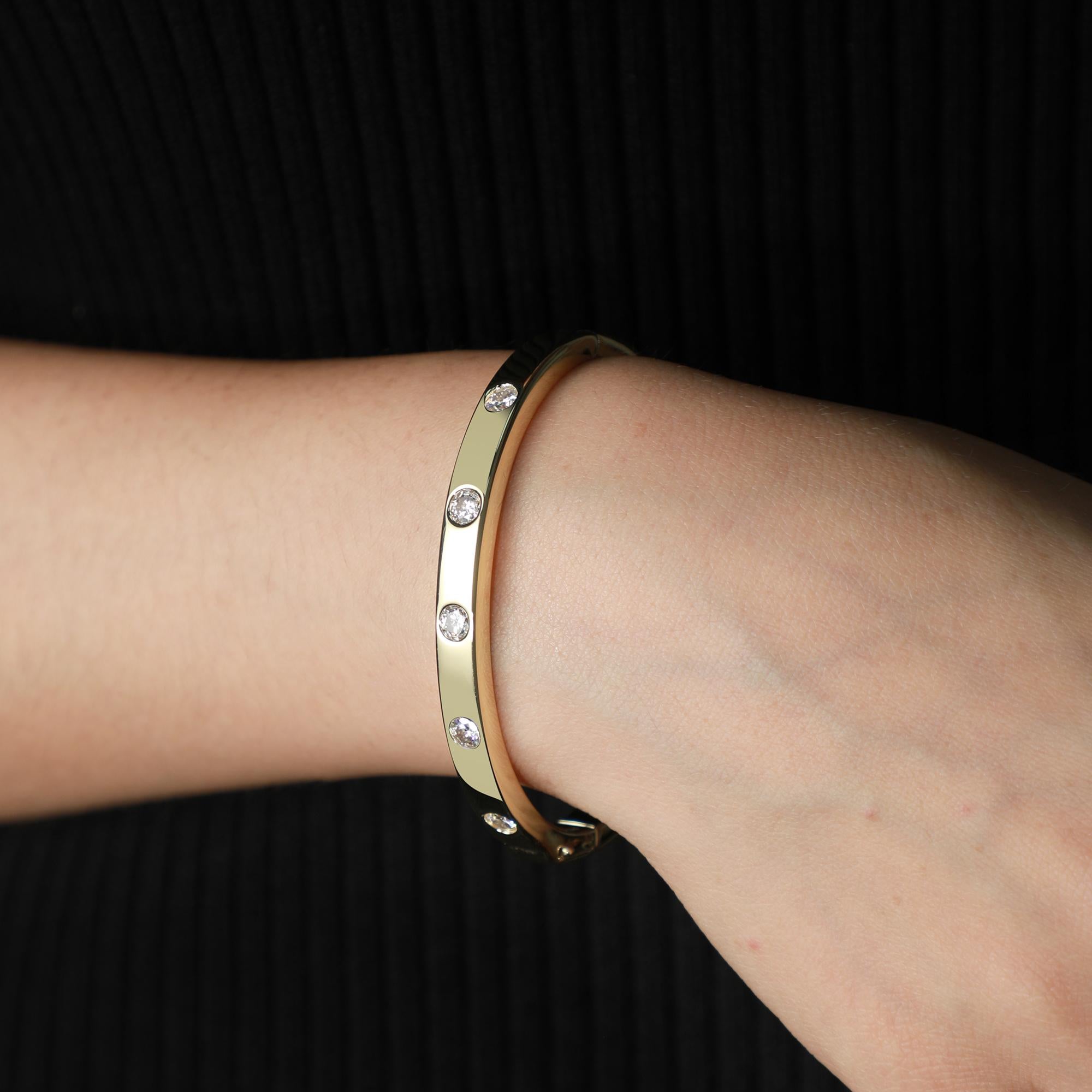 Elevate your style with the timeless elegance of our bezel-set golden bangle, a true beauty that enhances any wrist. This best-selling classic, meticulously designed by minimalist artist Vera at AdornA Lux High Jewelers, reflects the pinnacle of