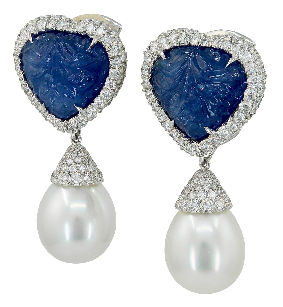 A pair of 18k white gold earrings, set with diamonds, two south sea pearls, and heart-shaped carved sapphire detachable ear clips, signed Haume.
Total Sapphire carat weight is approx. 60 cts. and diamonds are 8.13 cts. and each pearl is approx. 15mm