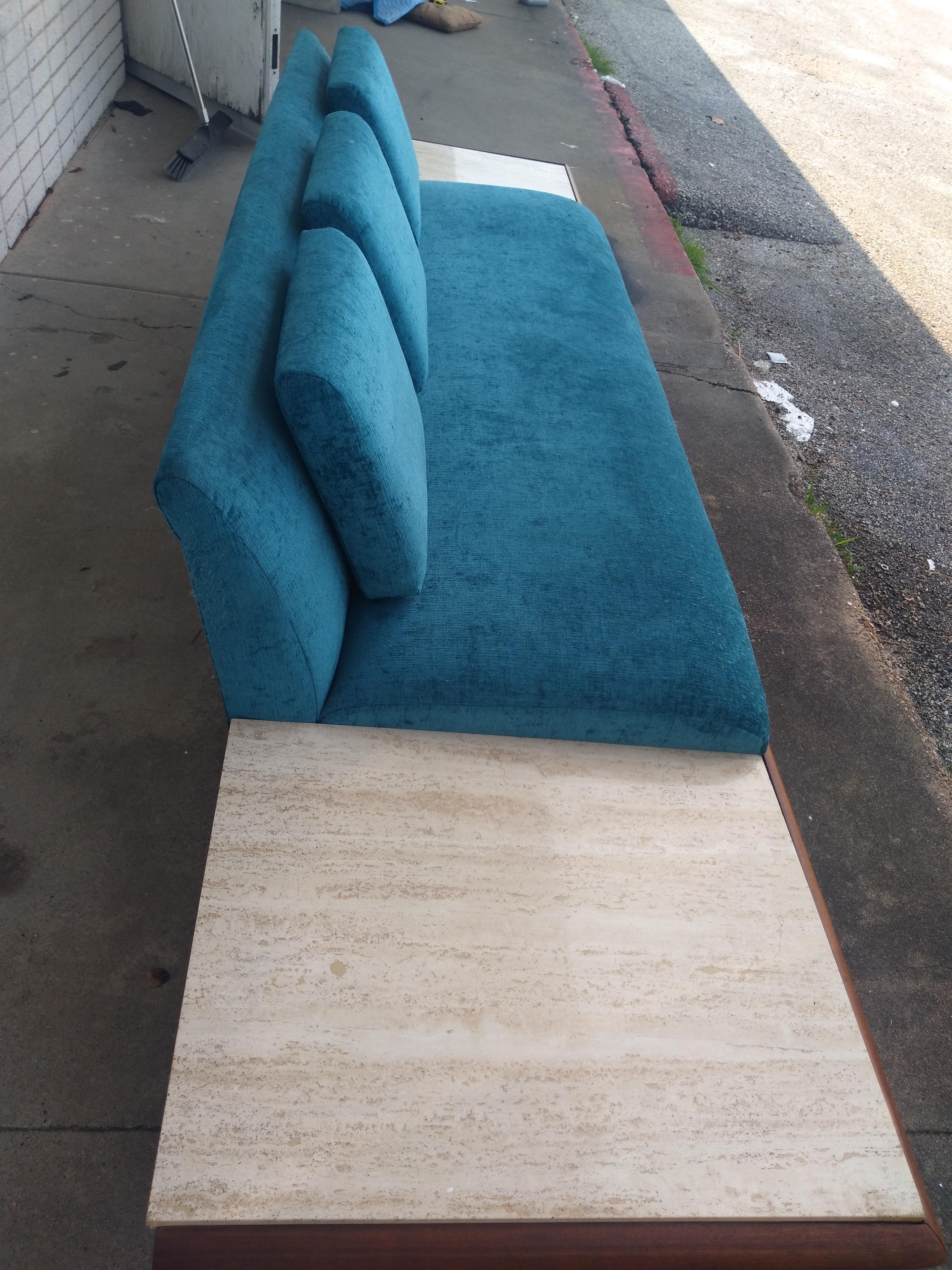 Adrian Pearsall designed this sofa/daybed for Craft Associates. It's 117.5' long and has Italian travertine marble built-in side tables. It's made of a choice selection of walnut and is reinforced by a hidden steel frame that causes the side tables