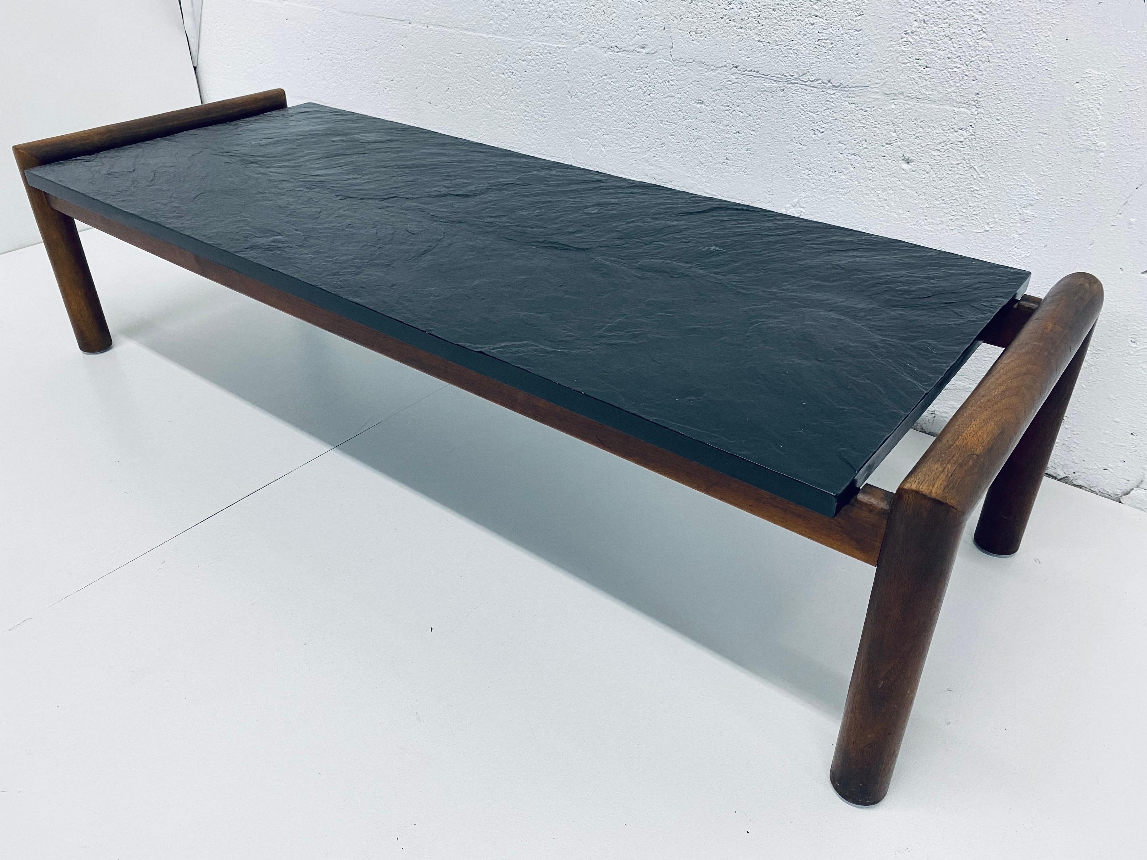 Midcentury black slate top on a walnut base coffee or cocktail table designed by Adrian Pearsall for Craft Associates.