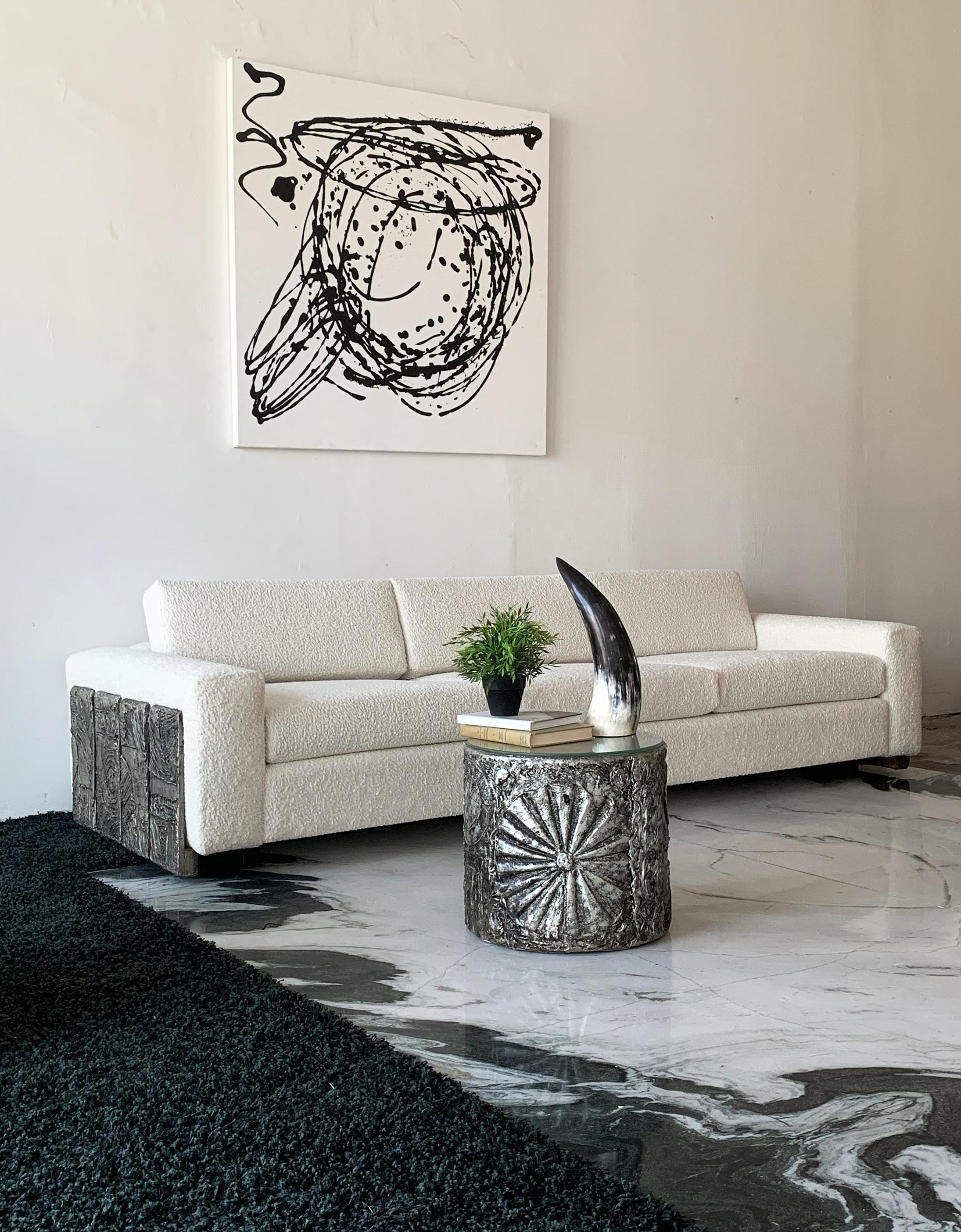 Designed by Adrian Pearsall, this brutalist panel sofa is stunning! With its thickly textured ivory boucle and heavily textured cast resin brutalist panel sides, It's a feast for the the eyes. The soft ivory boucle, sharp clean lines and timeless