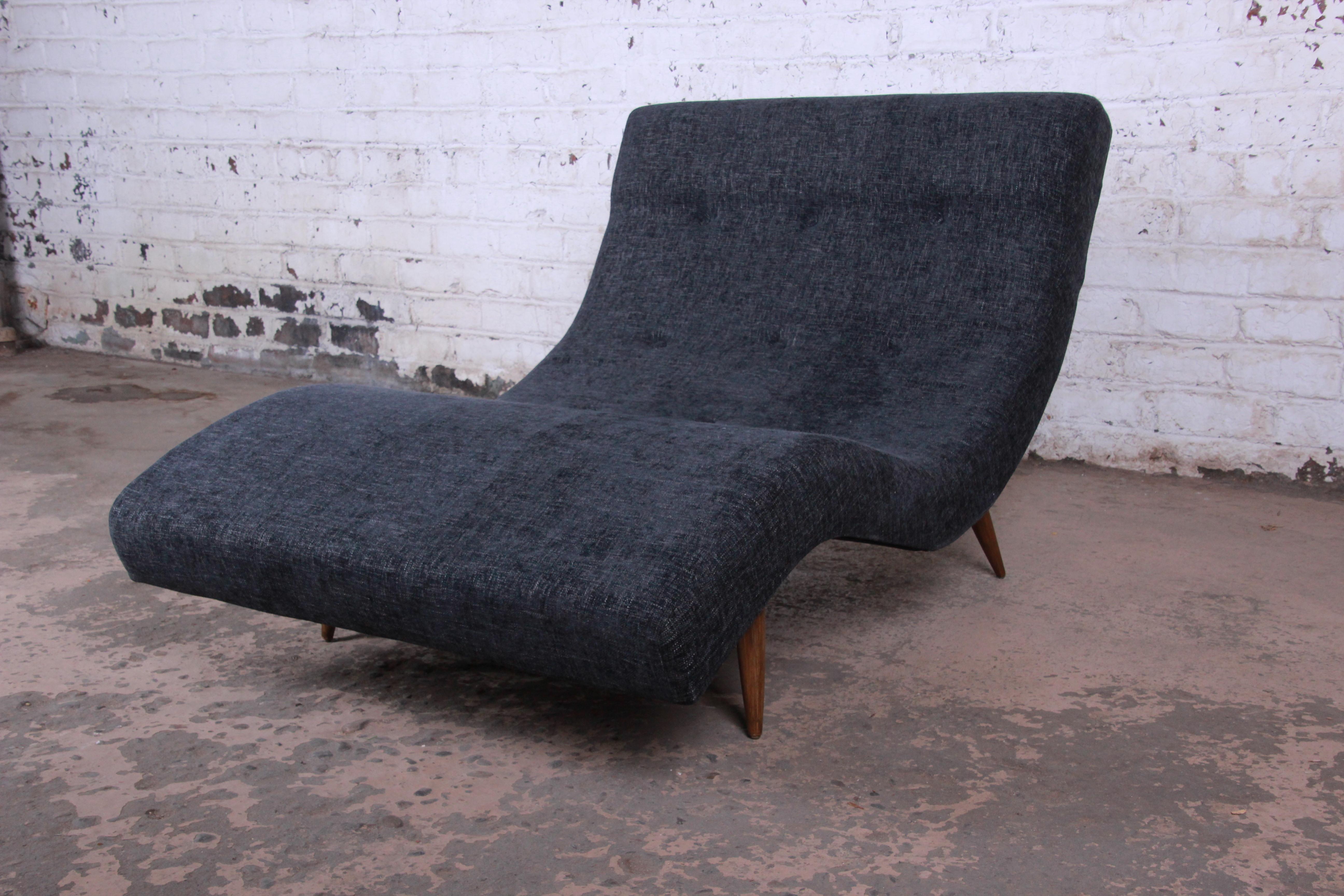 An exceptional Mid-Century Modern wave chaise lounge chair designed by Adrian Pearsall for Craft Associates. The chaise offers a unique blend of style and comfort. It features a dramatic wave design, with newly reupholstered charcoal fabric on