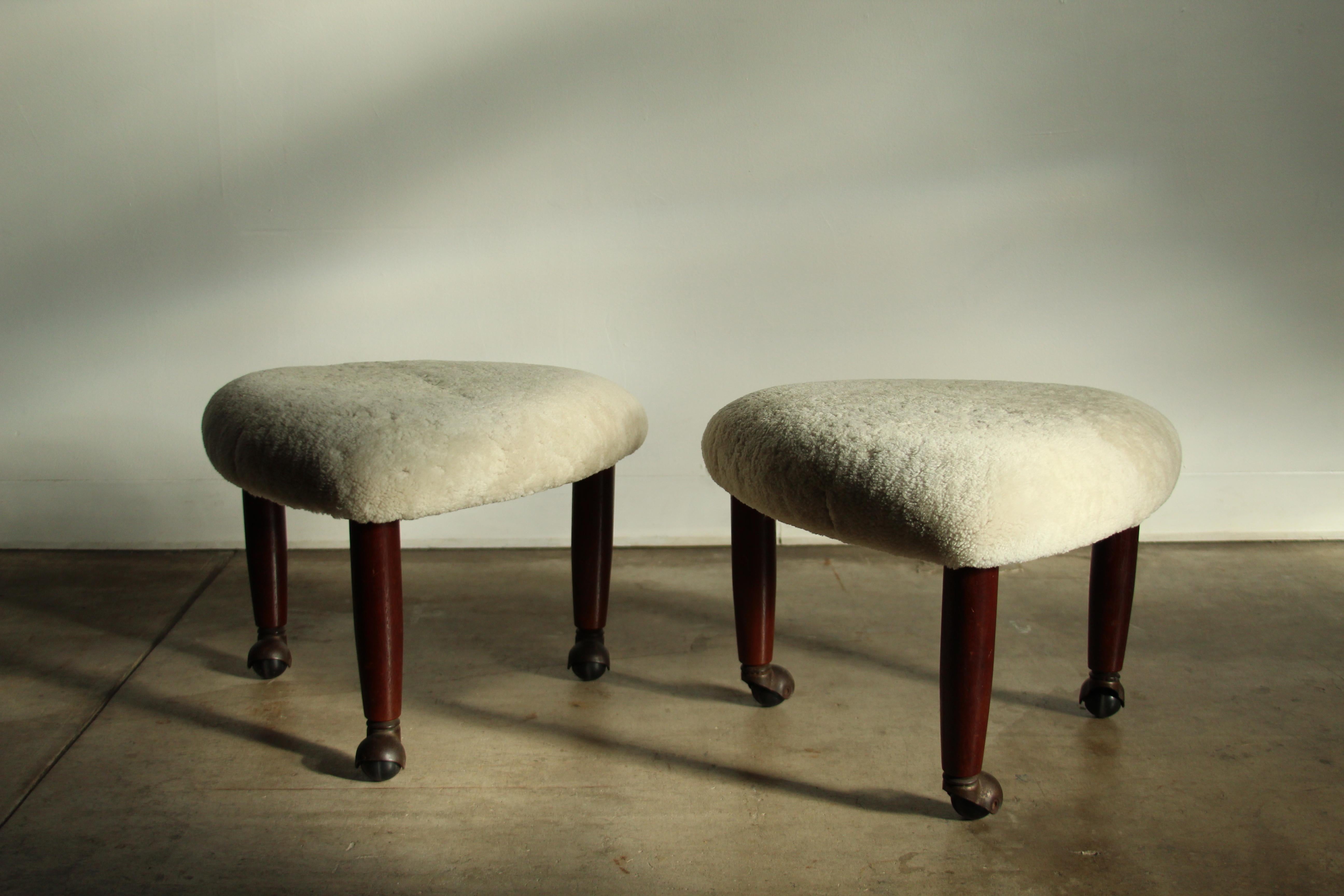 A fantastic pair of guitar pick form foot stools/ottomans designed by Adrian Pearsall and manufactured for Crafts Associates in the 1960s. Each stool featured three solid walnut, tapered legs with original casters. The seats have been freshly