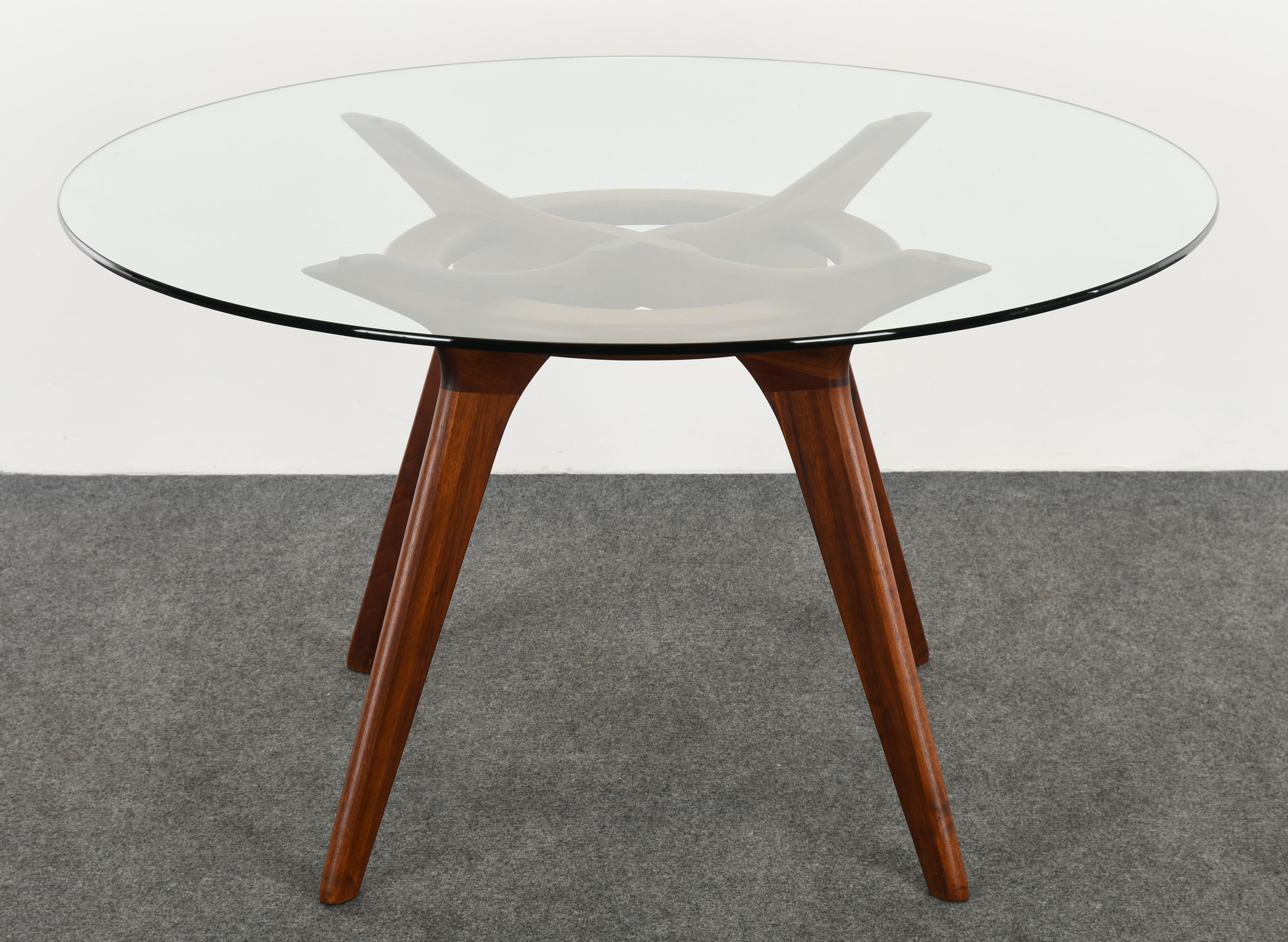 A beautiful Mid-Century Modern solid walnut dining table. This table is stunning at all angles. The table would look good in any modern or contemporary interior. The glass top was a custom size and is larger than the original. Some scratches to the