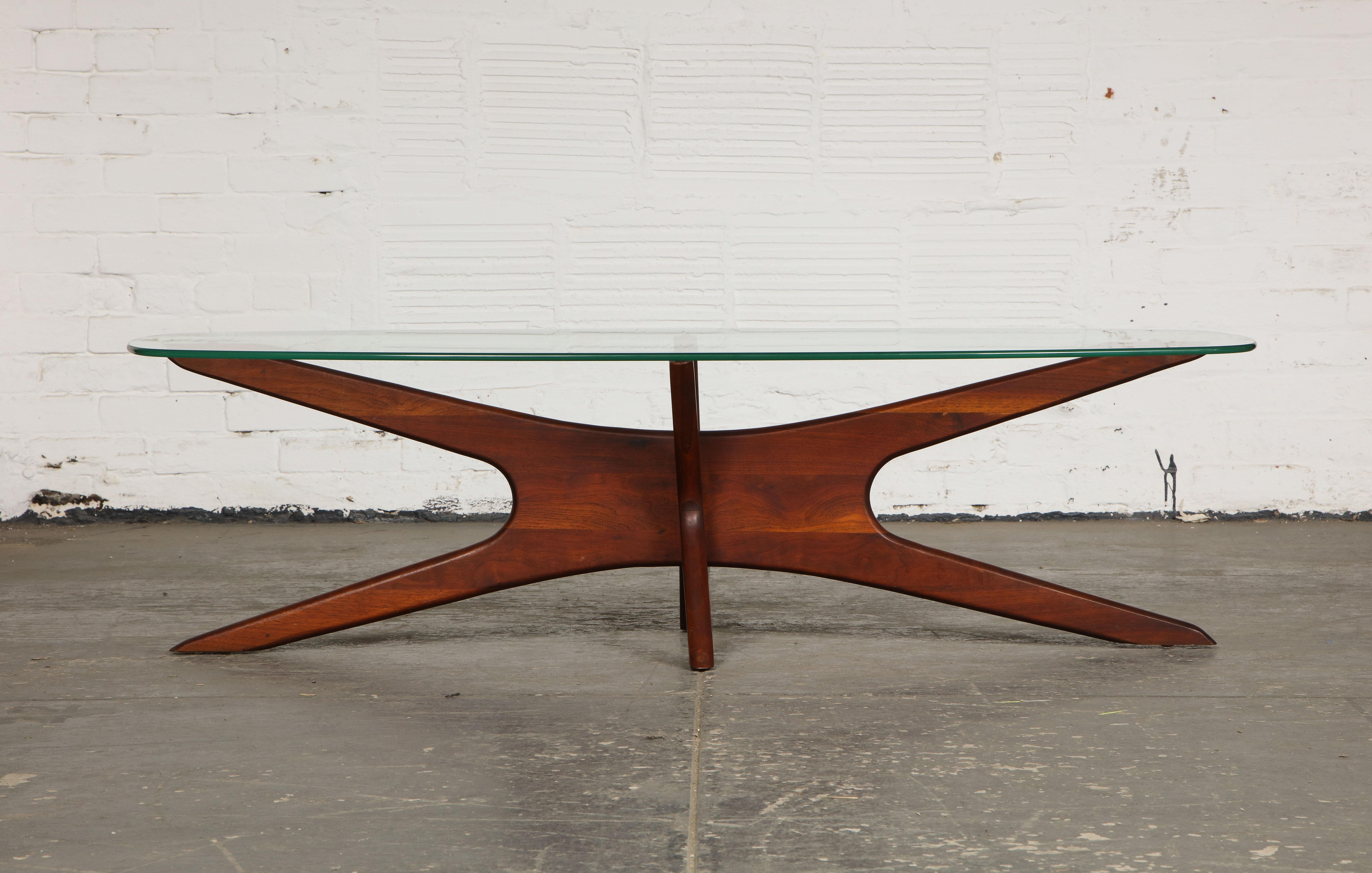 The glass biomorphic-shaped top resting on a walnut base.