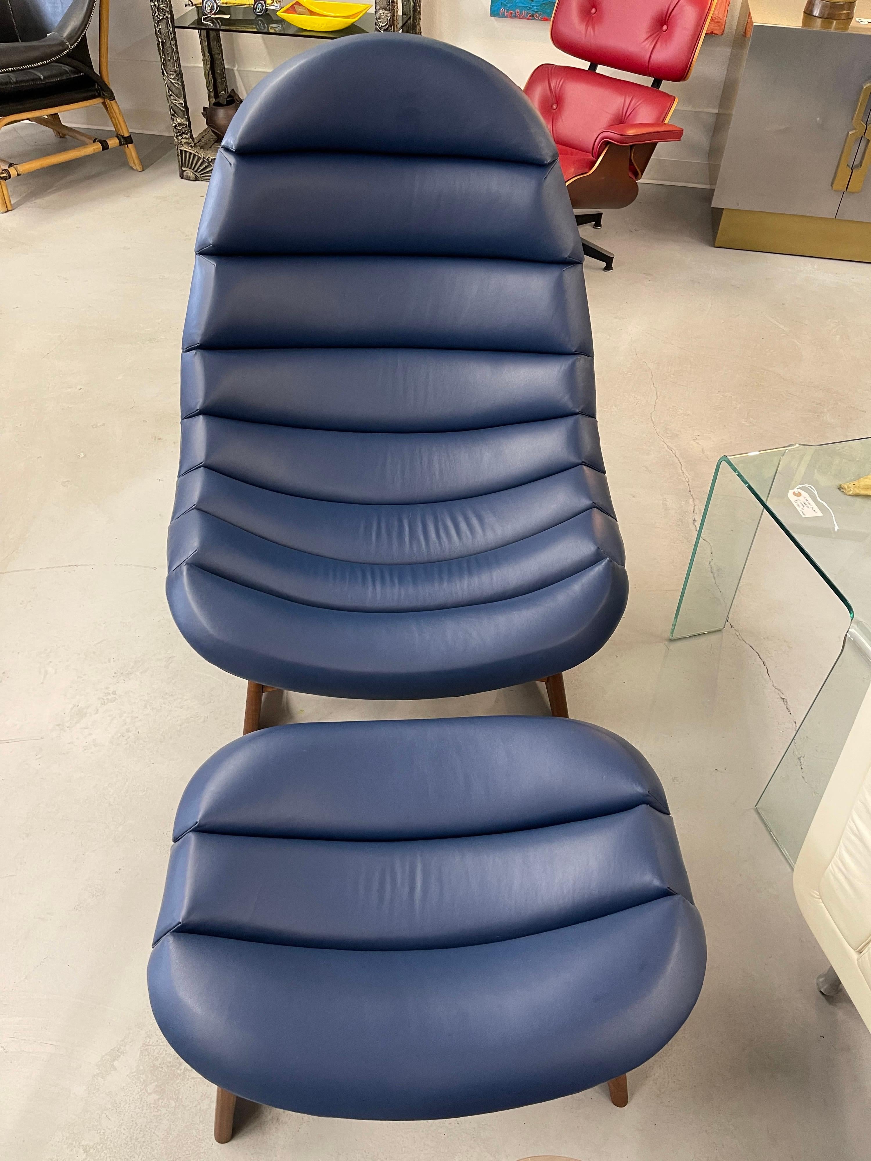 A stunning leather lounge chair and ottoman designed by Adrian Pearsall for Craft Associates. Features beautifully grained walnut bases. These chairs have been redone and reupholstered in a pretty blue leather at some point. Nicely channeled in good