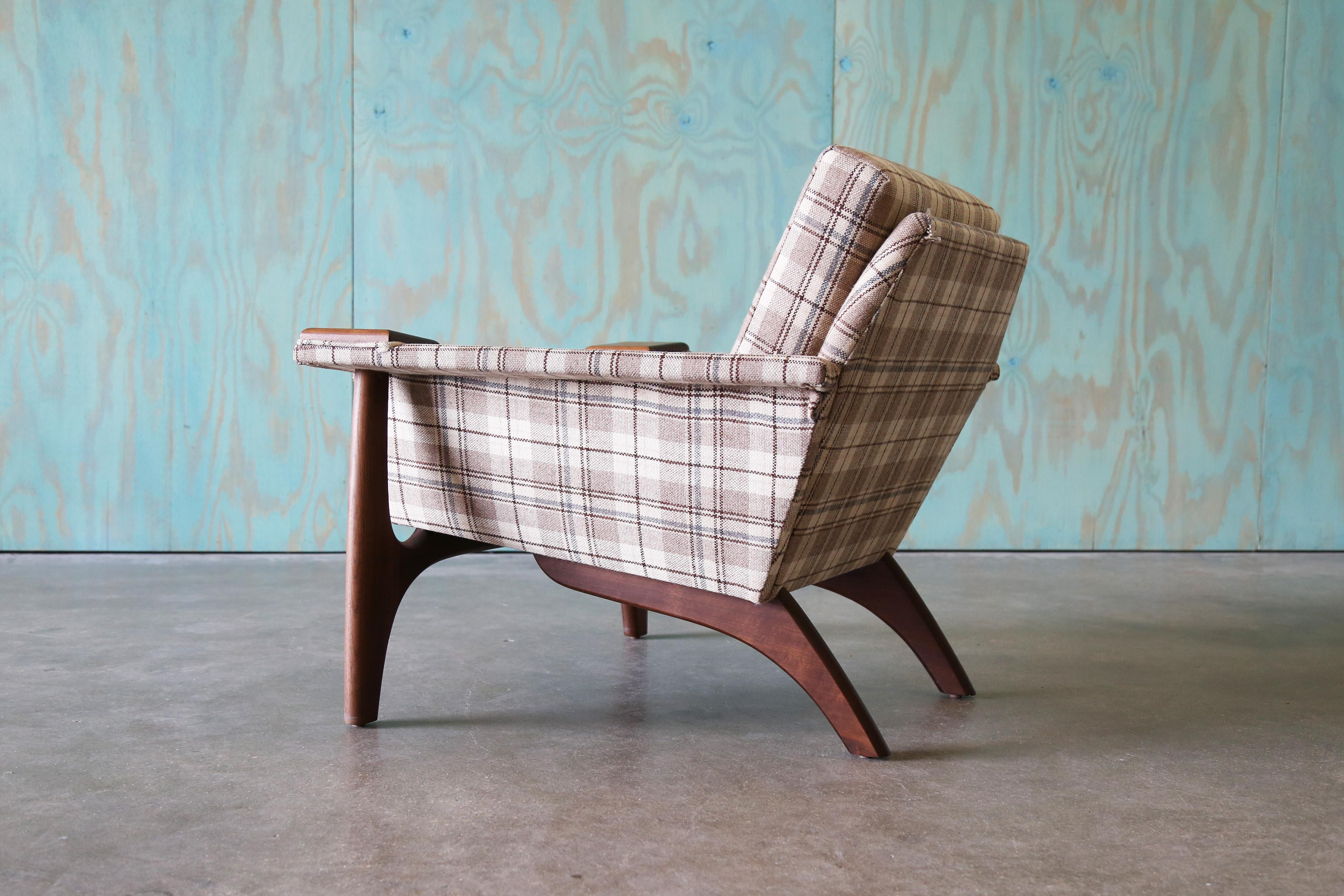 A lounge chair produced by the newer Craft Associates based on an early and rare Adrian Pearsall design. Solid walnut “paws” reminiscent of Hans Wegner’s Papa Bear chair. A fun plaid fabric, in style with the Ralph Lauren hunting lodge vibes but in