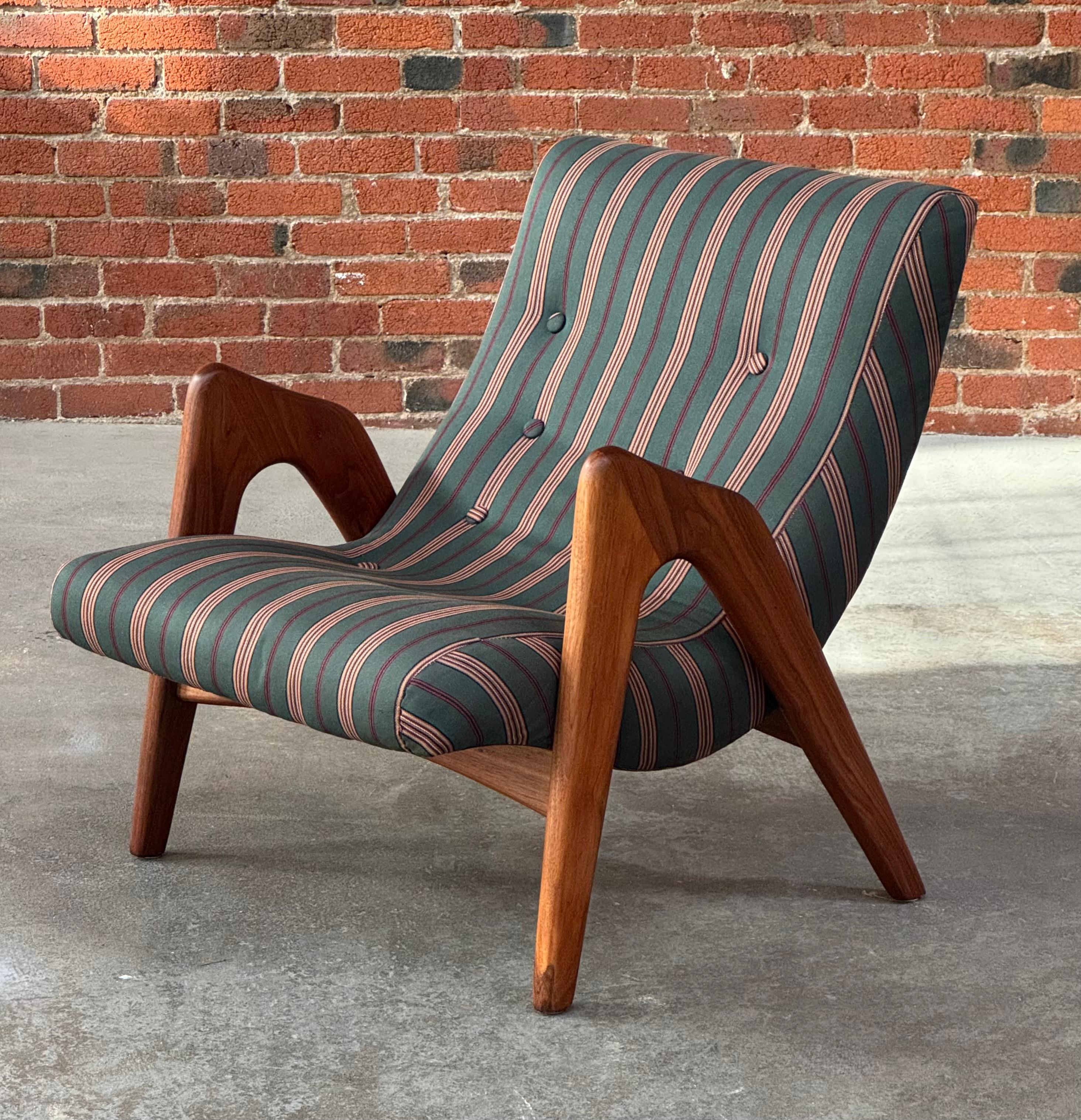 Chaise longue sculpturale construite en noyer et en tissu par l'architecte d'ingénierie Adrian Pearsall pour Crafts Associates. Cette chaise adopte une esthétique moderne organique avec des accoudoirs gracieux en noyer massif et une assise incurvée