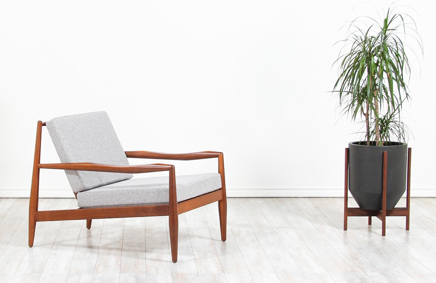 Stylish Mid-Century Modern lounge chair designed by Adrian Pearsall for Craft Associates in the United States, circa 1960s. The Model 843-C chair is built upon a solid walnut wood frame with scooped-shaped armrests that showcase a dynamic and visual