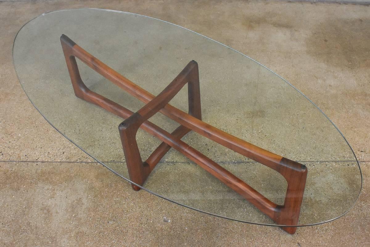 Beautiful sculptural solid walnut coffee table designed by Adrian Pearsall for Craft Associates. The base is in excellent original condition. The original glass does show some notable scratching, though it is difficult to show in the