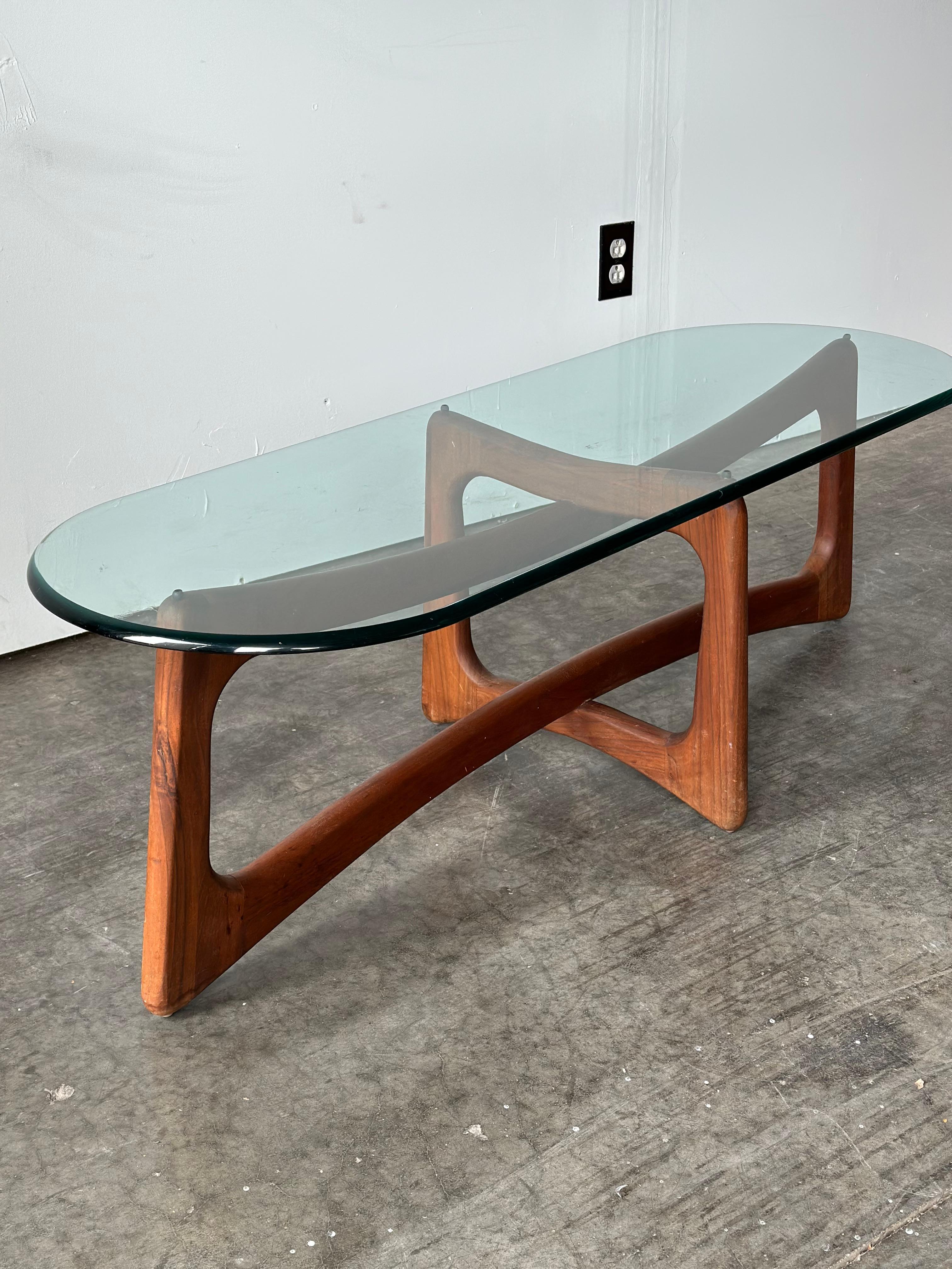 Adrian Pearsall Ribbon coffee table featuring a walnut base and a tempered oval glass top. Base is in excellent condition. The glass top has minor scratches associated with normal use. Would perfectly showcase terrazzo flooring or a vibrant rug
