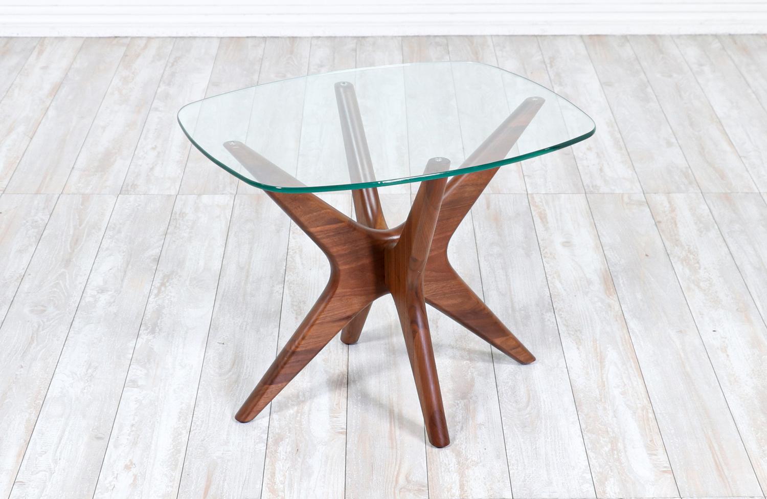 Side table designed by Adrian Pearsall for Craft Associates and manufactured in United States circa 1960’s. The beautiful new glass top show a beautiful view of the frame of the table and contrast exquisitely with the walnut wood jax-shaped base