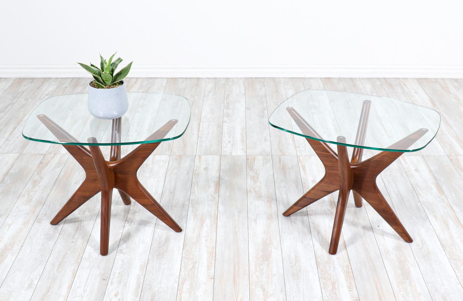 A pair of side tables designed by Adrian Pearsall for Craft Associates and manufactured in United States circa 1960’s. The beautiful new glass tops show a beautiful view of the frame of the tables and contrast exquisitely with the walnut wood