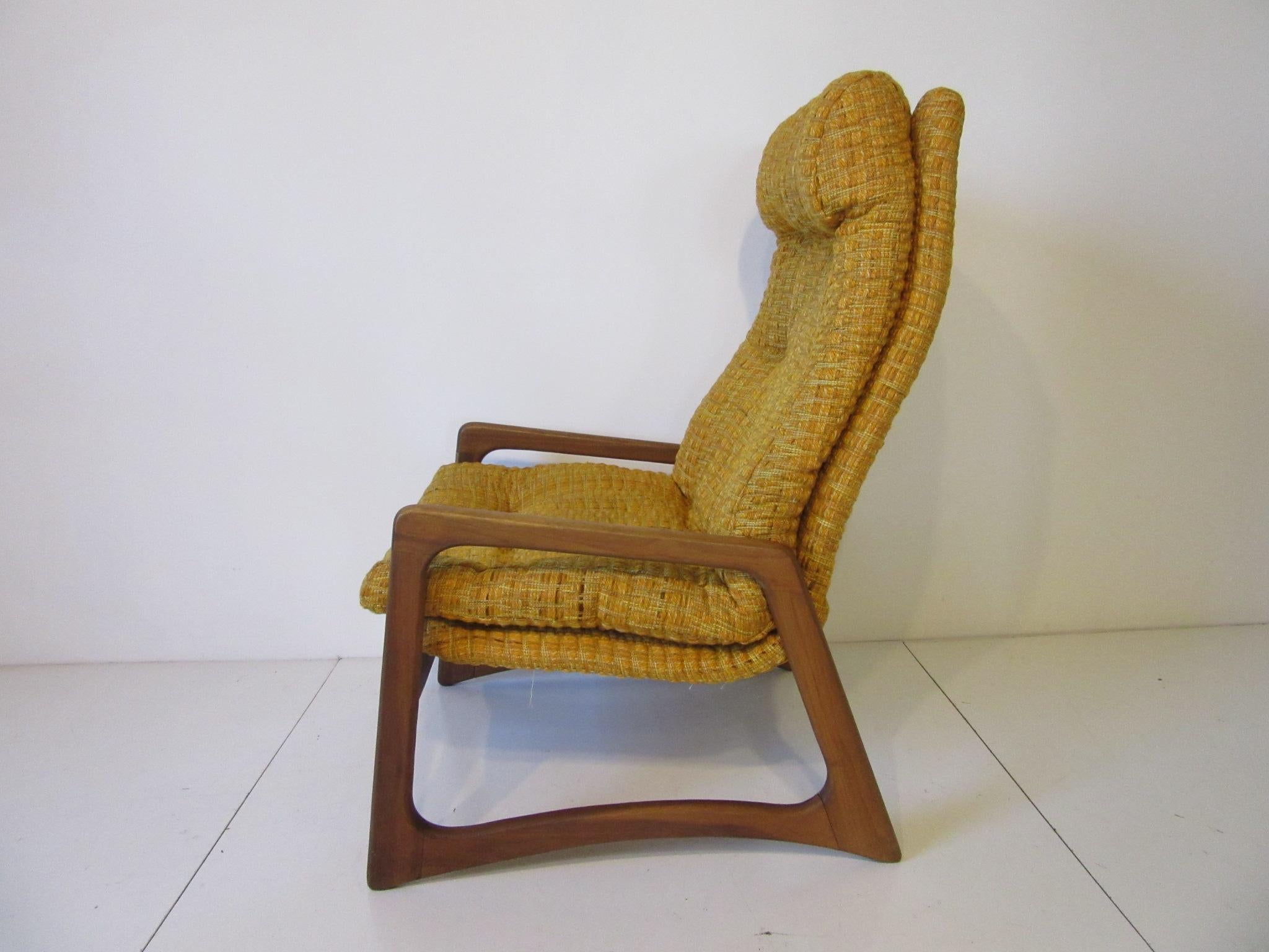 A sculptural solid walnut framed lounge chair with button details to the original upholstery which is a soft orange, gold and yellow woven fabric . Designed by the American craftsman and manufacturer Adrian Pearsall and produced by this company
