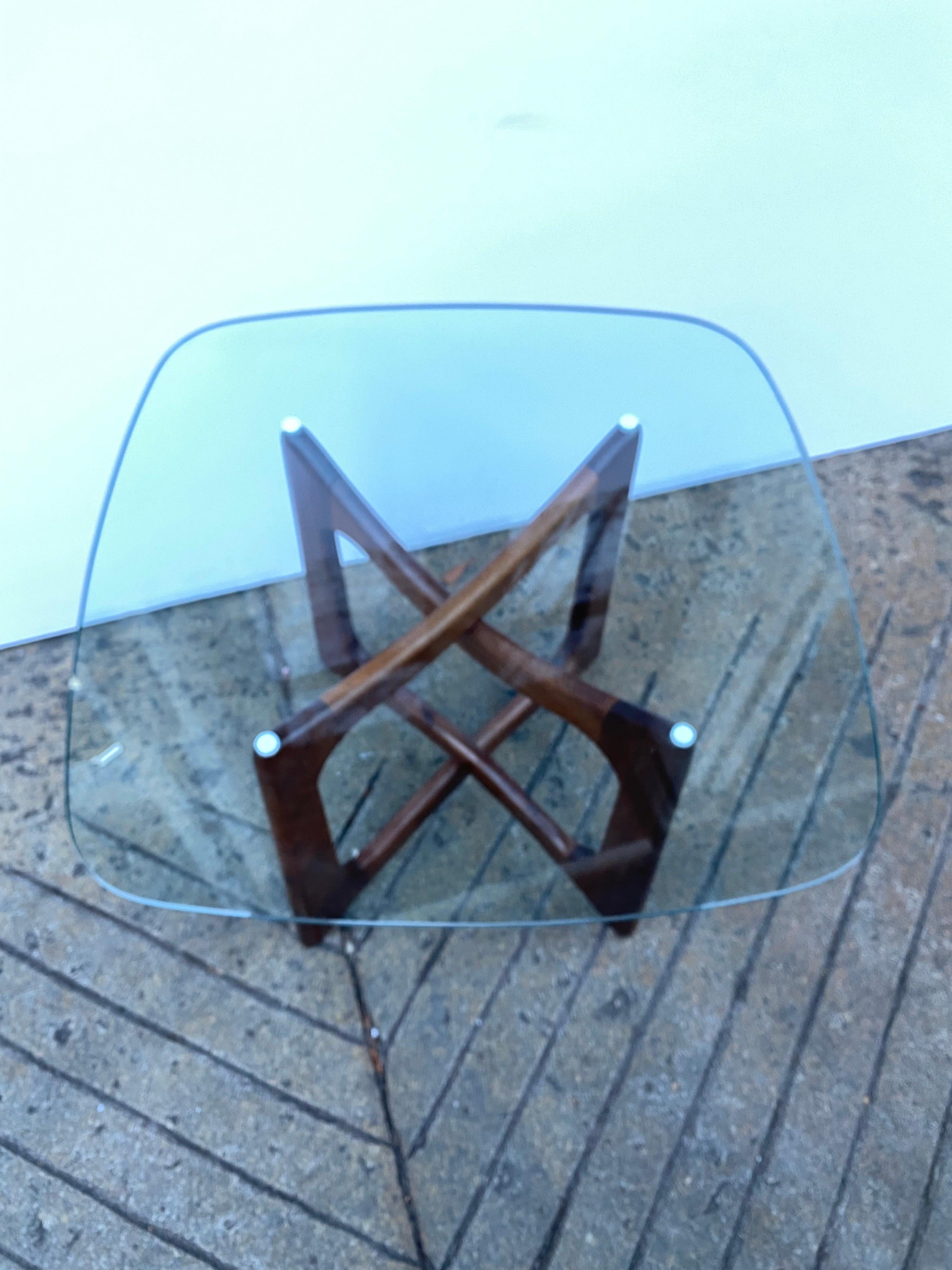 Classic glass top side, or end table designed by Adrian Pearsall. The table has a square glass top with rounded corners, and features an organic form interlocking walnut base.