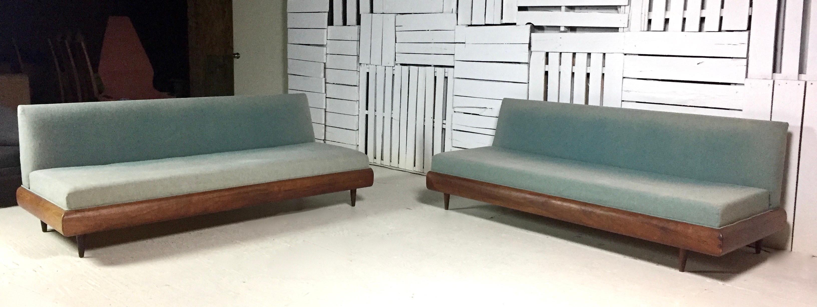 Adrian Pearsall two-piece sectional sofa by Craft Associates, circa 1960s, features a walnut wood frame which could use some conditioning. The sofa comes in two pieces with sea green synthetic fabric that needs to be reupholstered. Additionally,