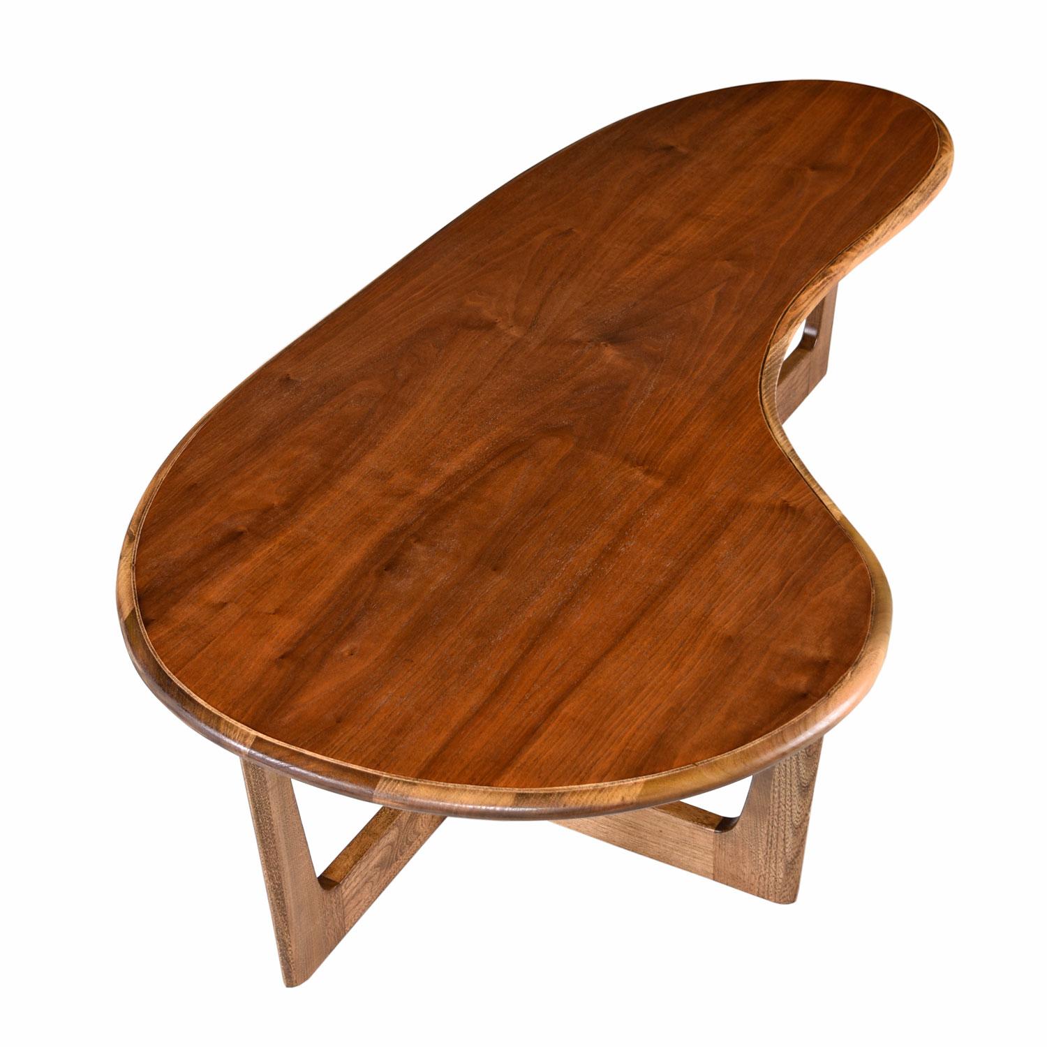 This Mid-Century Modern amoeba coffee table exhibits amorphic design reminiscent of works by Adrian Pearsall. The cross beam trestle style solid oakwood base perfectly balances the boomerang shaped top. This piece is all solid oak with a stunning,