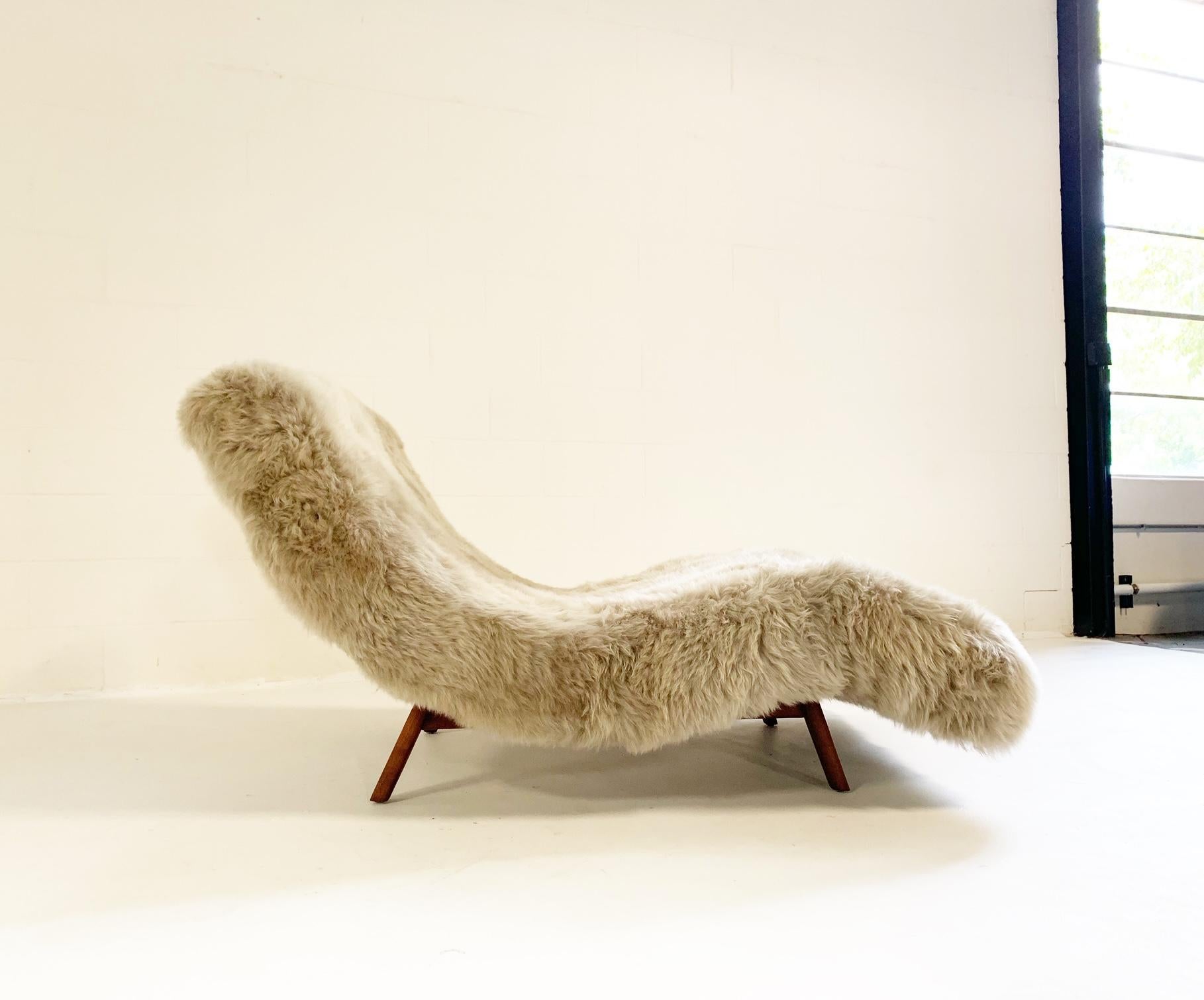 A stunning Adrian Pearsall style wave chaise lounge. We upholstered this chaise lounge in our thick and super soft New Zealand sheepskin after our master upholstery team completely restored the interior foam and cushioning. We love how the cozy,