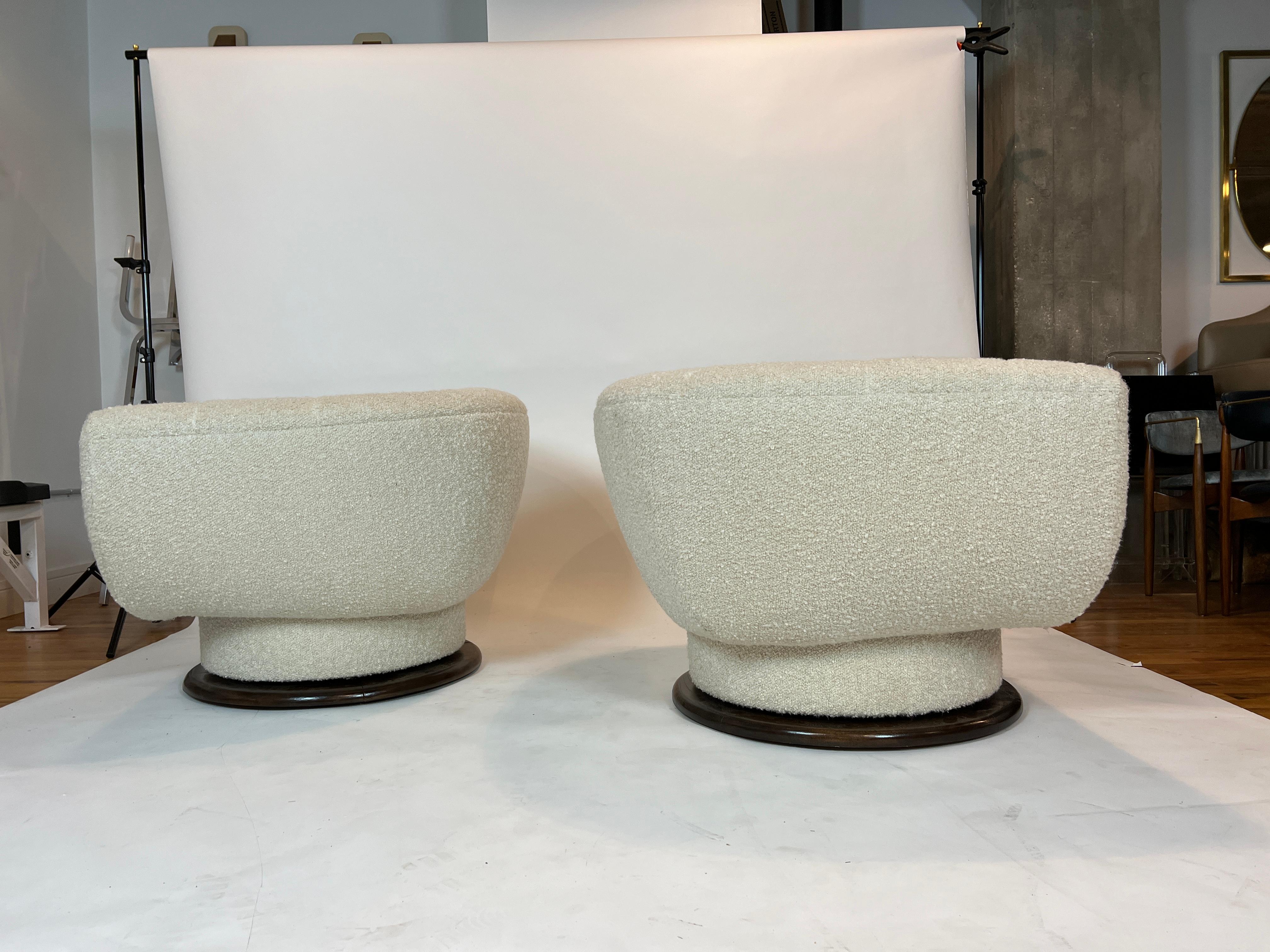 Very rare pair of barrel swivel chairs attributed to Adrain Pearsall for Craft Associates, 1960’s. Each chair swivels 360 degrees and have been restored and reupholstered in an ivory boucle. The wood base has been restored in a dark walnut finish.