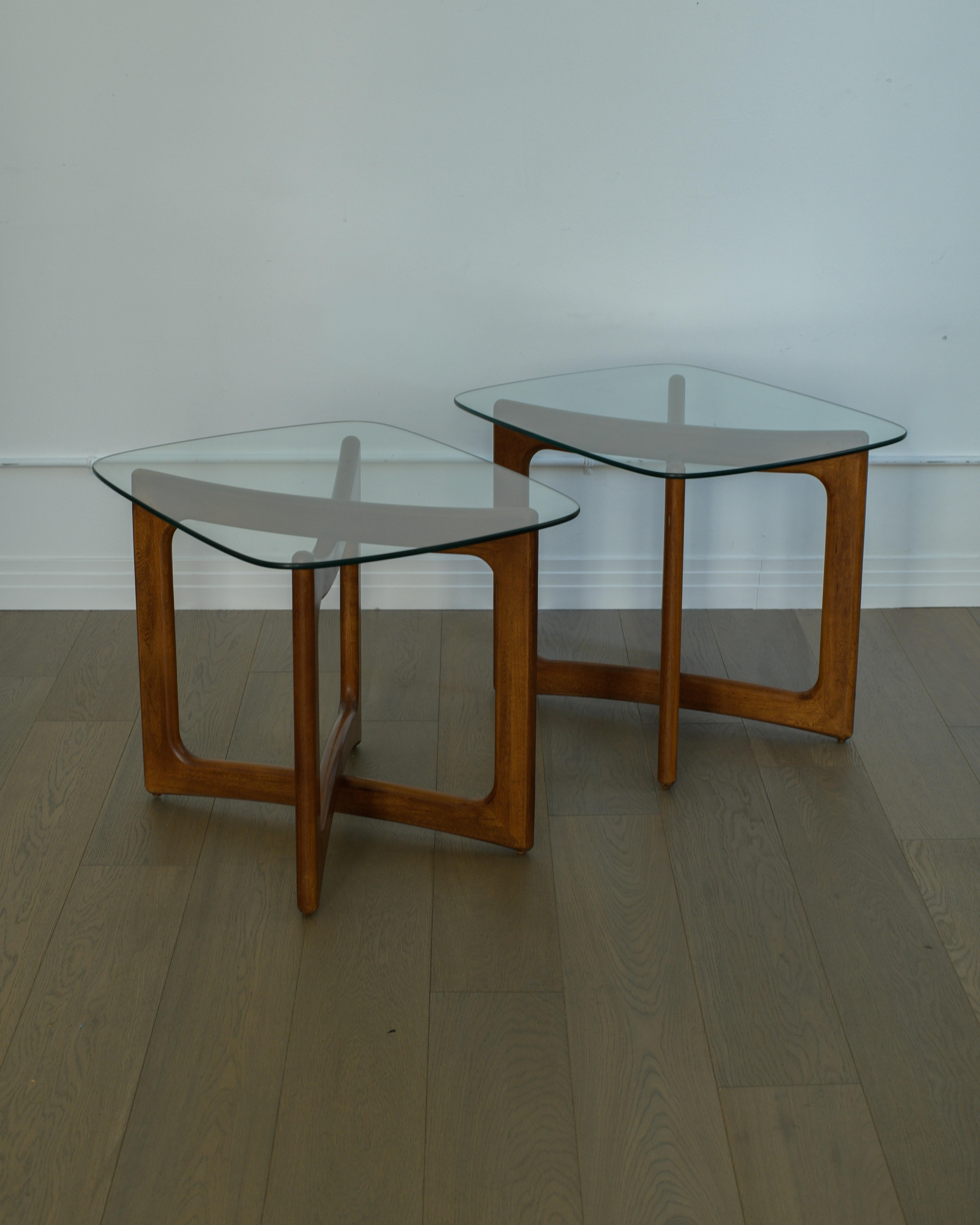 Très belle paire de tables d'appoint Adrian AGE en noyer et verre, en bon état, avec une belle patine d'usage. 

Les cadres en noyer présentent quelques petites abrasions éparses. L'un des plateaux en verre présente quelques fines rayures de 4