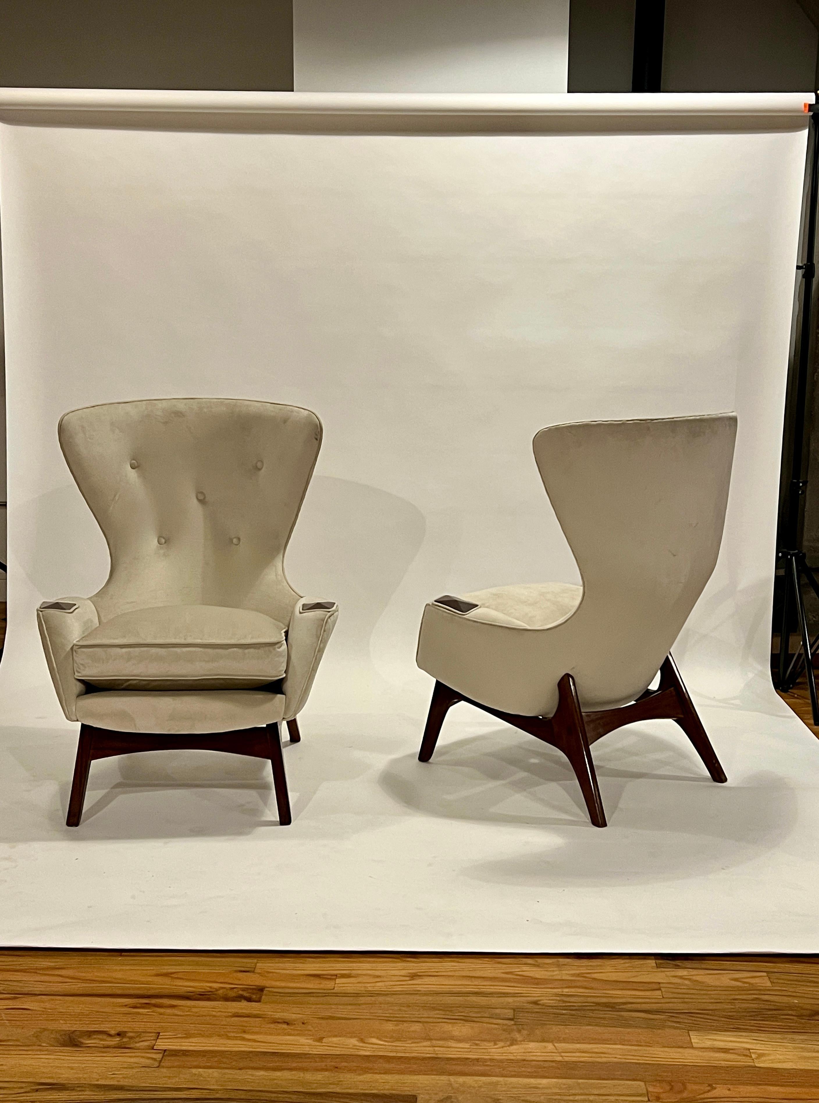 Pair of Adrian Pearsall wing chairs in beige velvet and dark walnut frame and accents. These chairs are sold as acquired and is in good vintage condition showing little wear but it's not the best upholstery job. We have sold several of these chairs