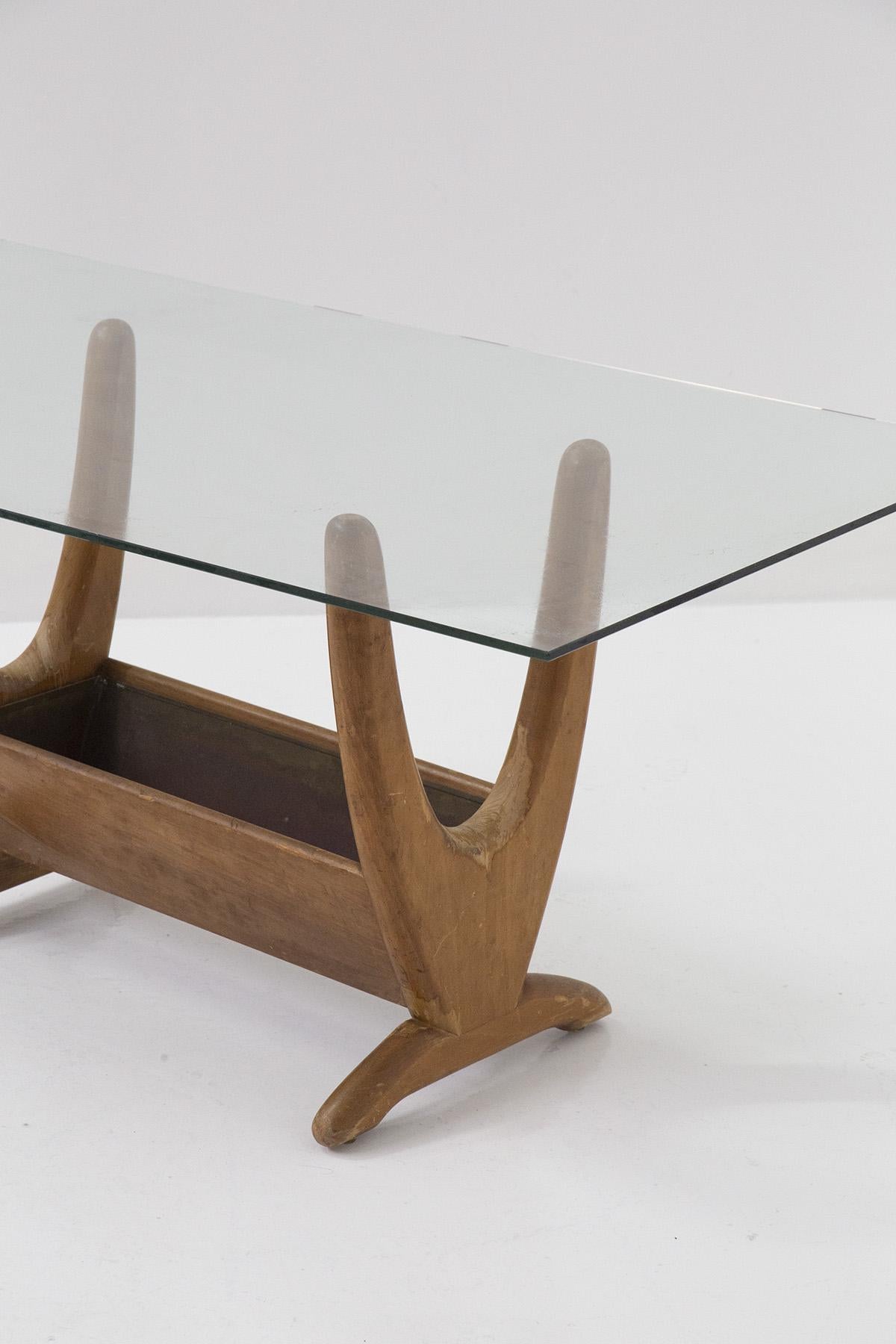 Une élégante table basse en bois et en verre conçue par Adrian Pearsall Attr. dans les années 1960. 
La table basse se compose d'un solide cadre en bois clair qui prend une forme très sinueuse. Un compartiment de rangement est visible au centre, qui