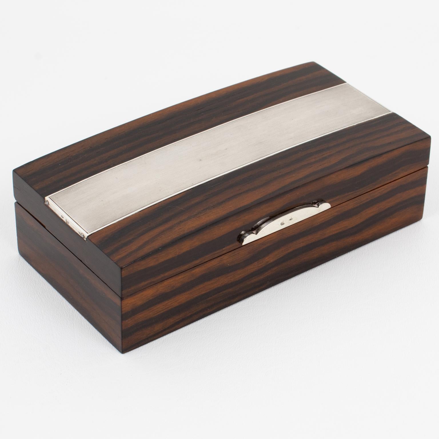 Si tratta di una lussuosa scatola con coperchio in legno Art Déco e argento sterling, realizzata a mano dall'argentiera Adriana Binazzi. Questo raro pezzo è stato realizzato a Firenze, in Italia, intorno al 1930. La forma rettangolare vanta una