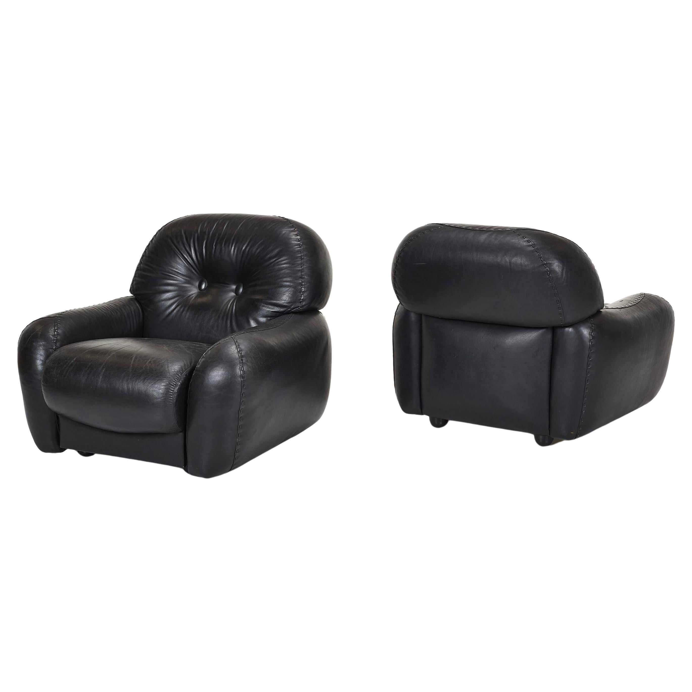 Pareja de originales sillones de salón vintage de cuero negro y una otomana diseñados por Adriano Piazzesi, años 70. Estupendo cuero negro suave original con detalle de costuras de béisbol de la firma.

Fabricado por POL 74, Italia. Parte inferior