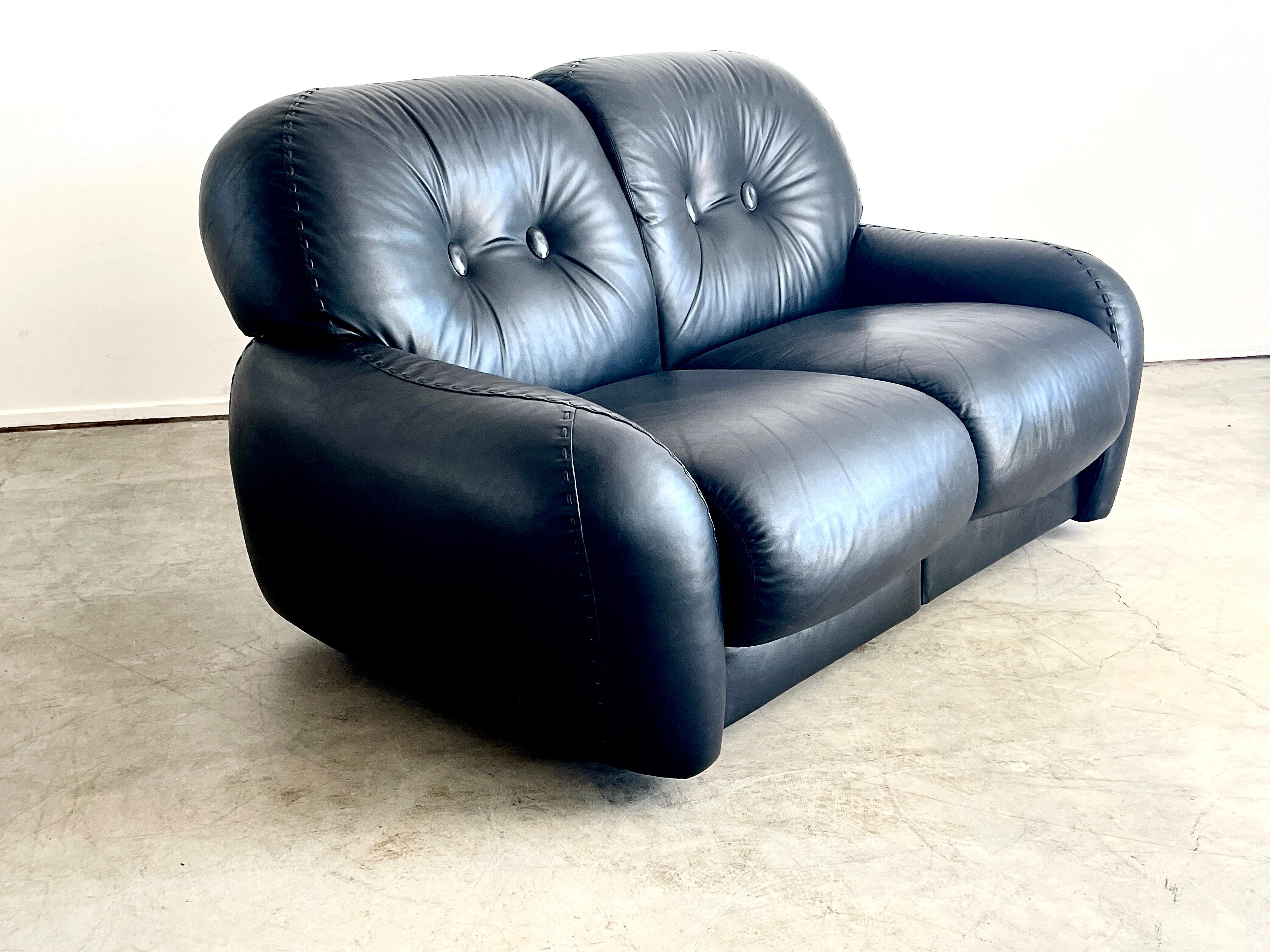 Italian leather settee by ADRIANO PIAZZESI, circa 1960's.
Part of a set with matching 4 seat sofa and pair of club chairs with ottoman.
 (sold separately) 
Great original black leather with 2 seats that have a feature that slightly reclines each