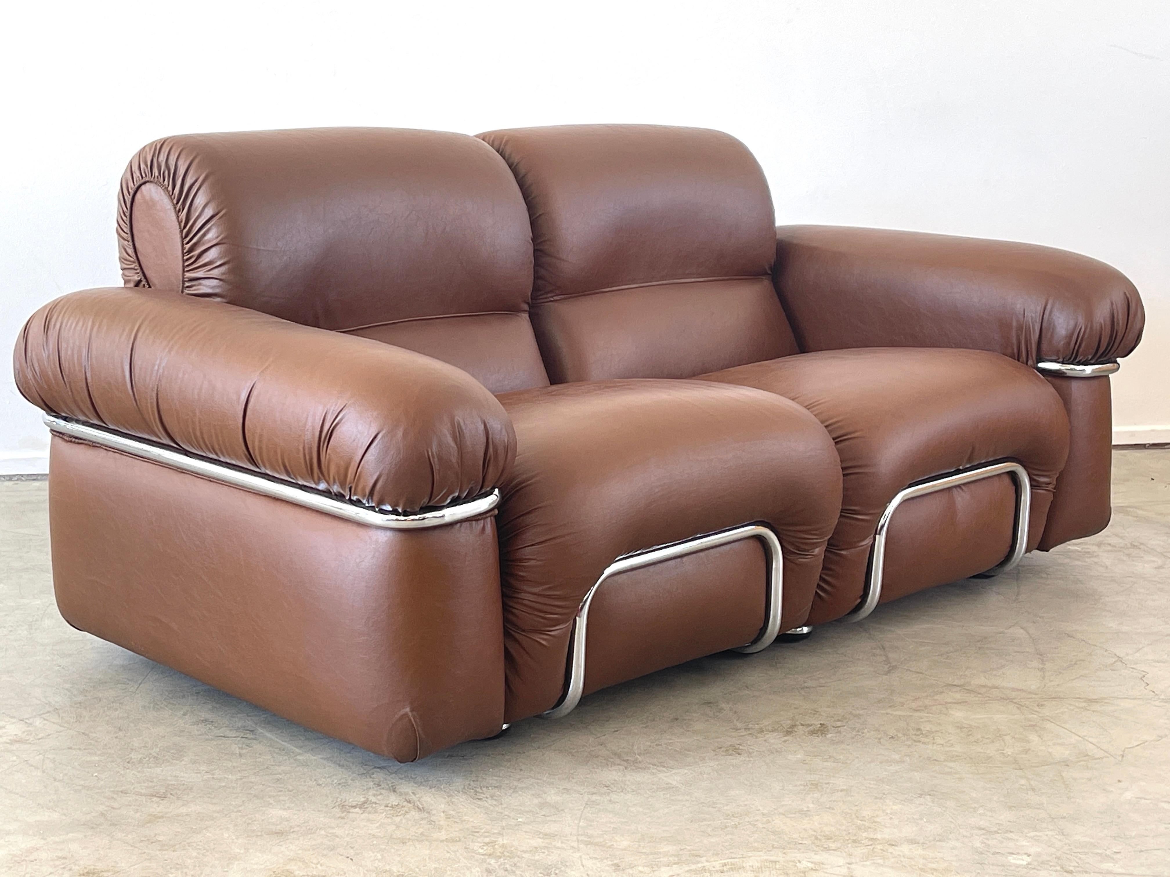 Handsome Adriano Piazzessi Italian leather loveseat / sofa with curved tufted sides and chrome detailing. Wonderful chocolate brown leather with tacking hardware along back. 
Italy, 1970's.