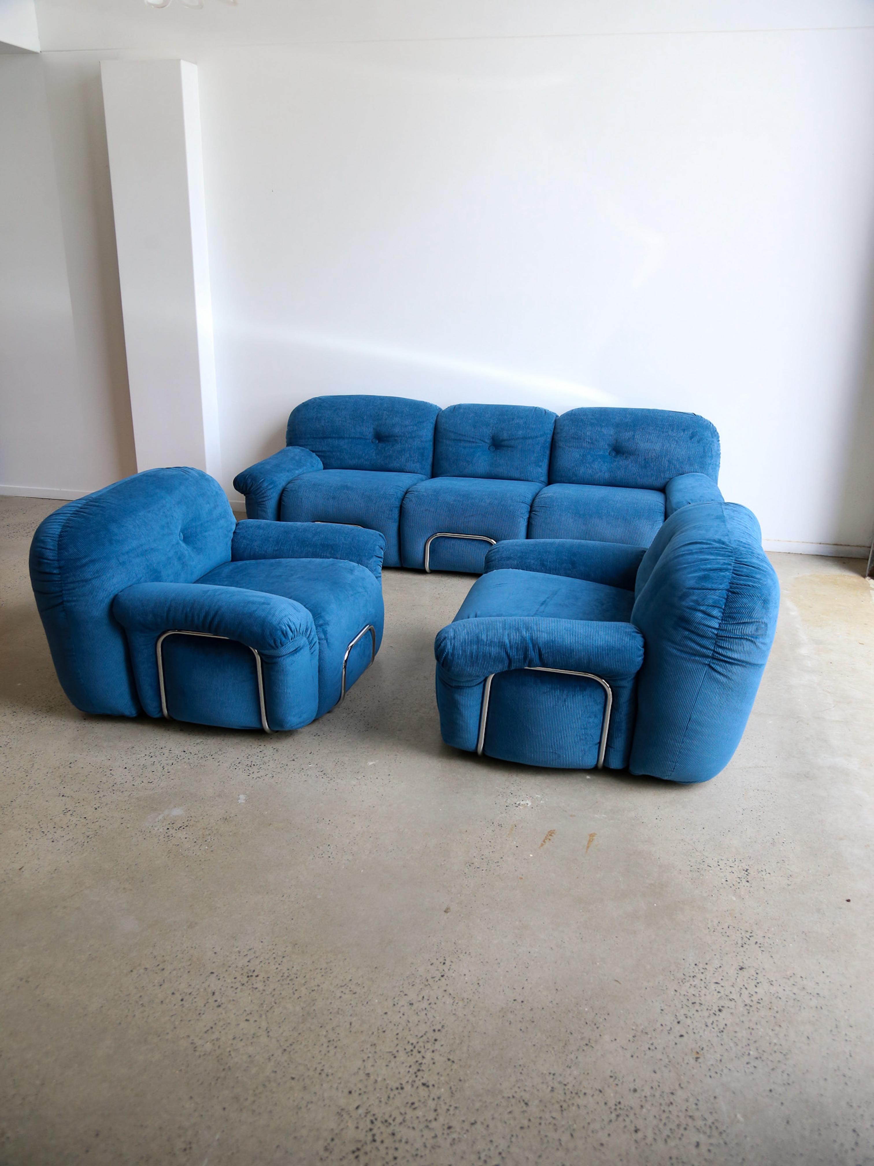 This exquisite modular sofa set by Adriano Piazzesi combines comfort, sophistication, and iconic 1970s Italian design. Upholstered in plush blue corduroy fabric and accented with sleek chrome details, this versatile seating arrangement embodies