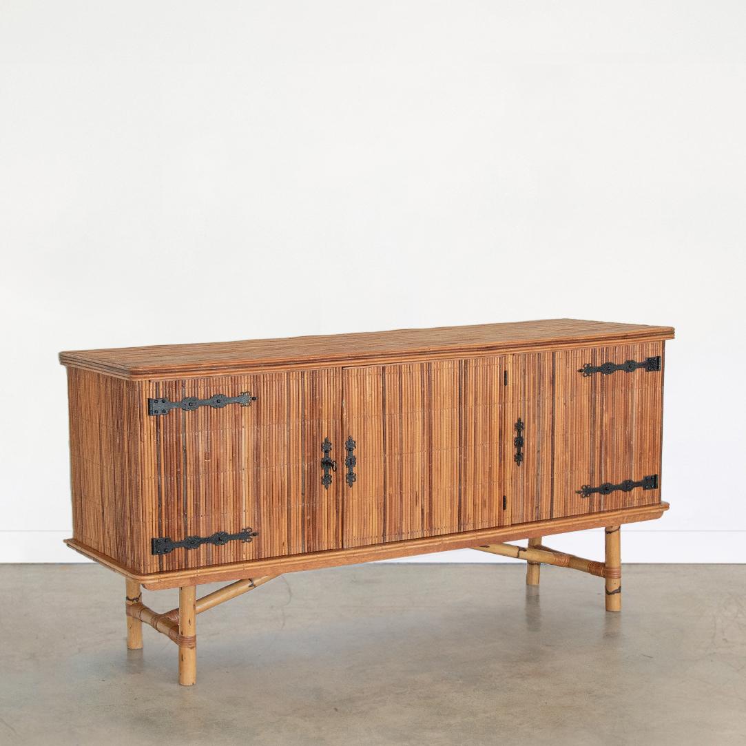 Beautiful split bamboo sideboard by Adrien Audoux and Frida Minet from France 1960's. Three-door cabinet with intricate wrought iron hinges, interior shelf, and original key. Thick bamboo legs with wrapped rattan detail. Original finish shows